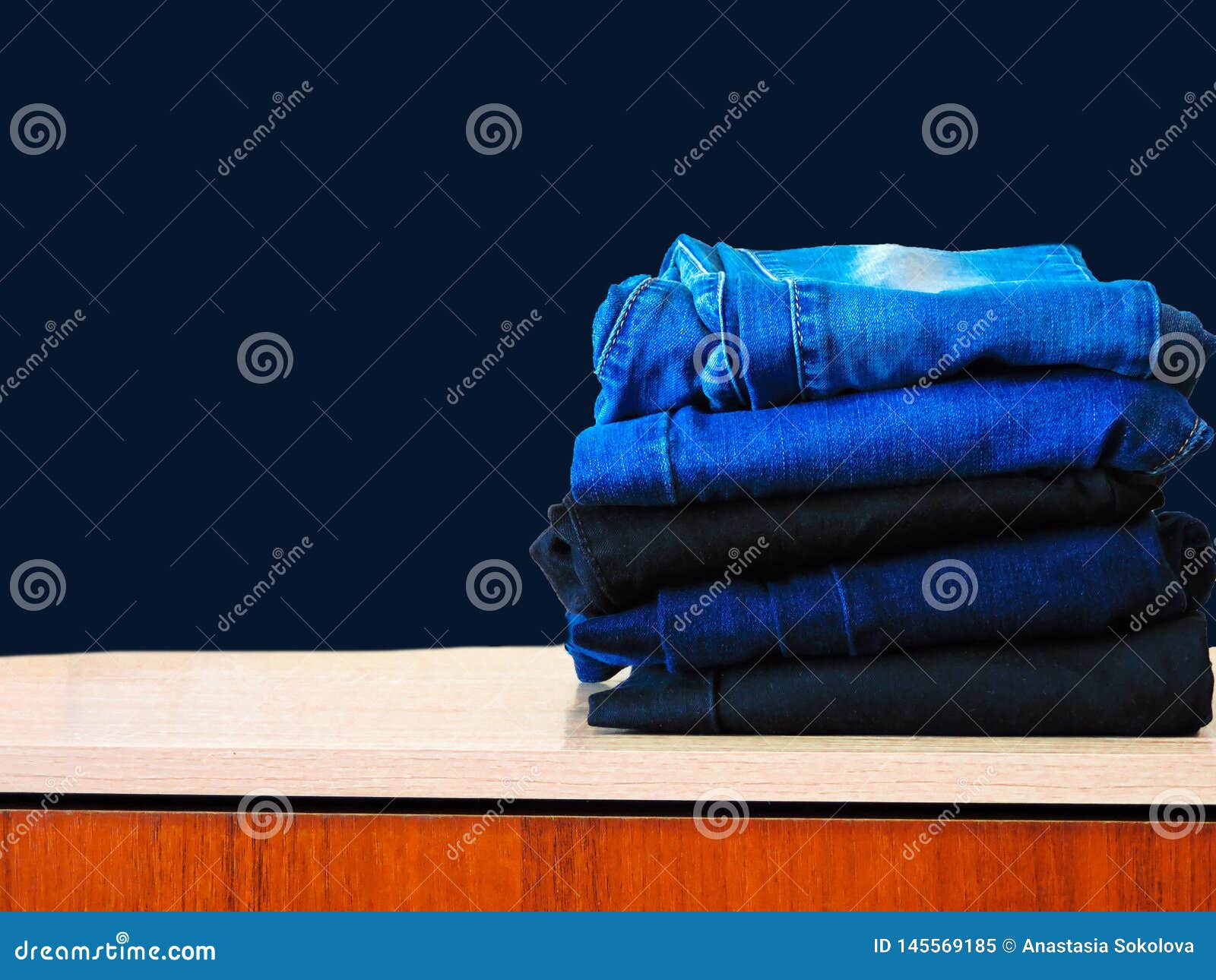 Blue Jeans Isolated on Blue Background. Jeans Stacked on a Light ...