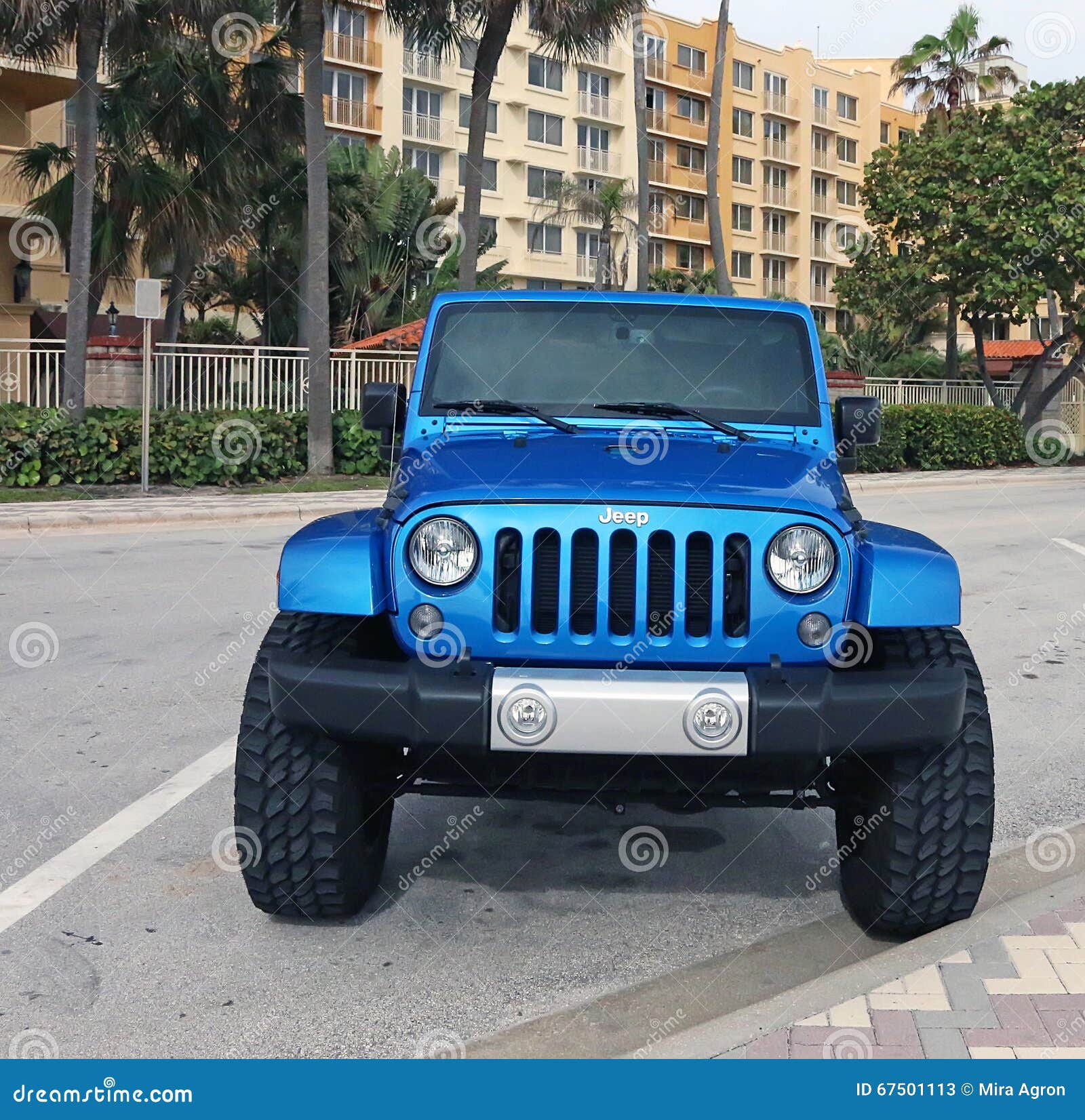 A red jeep parked in front of a louis vuitton store photo – Free