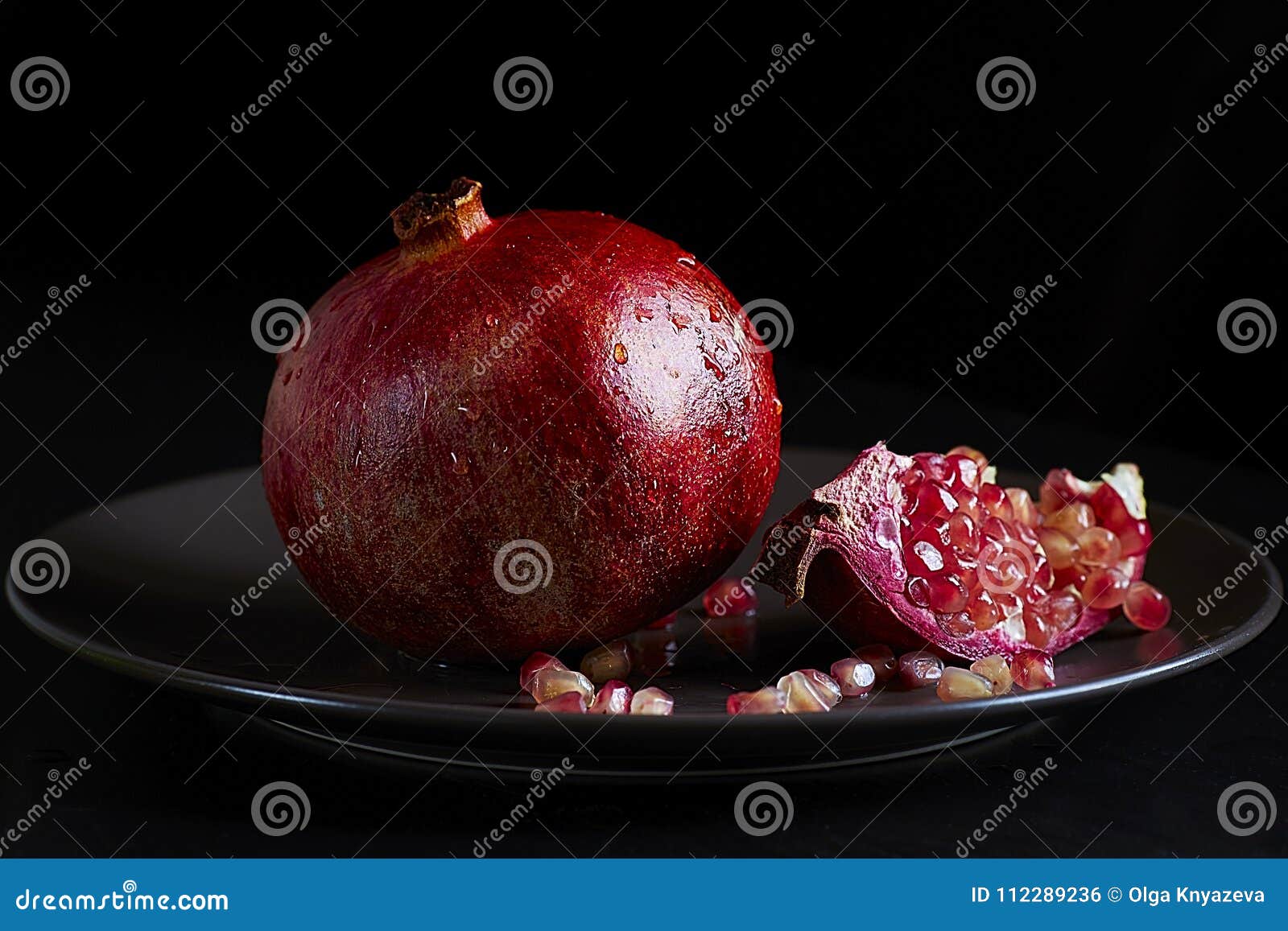 blue lared fruit garnet lies on a plate on a dark backgroundke in the mountains