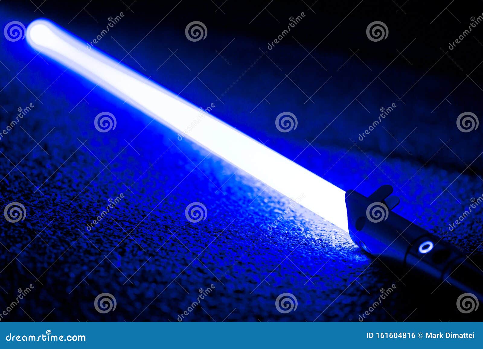blue light sword saber laying on carpet floor