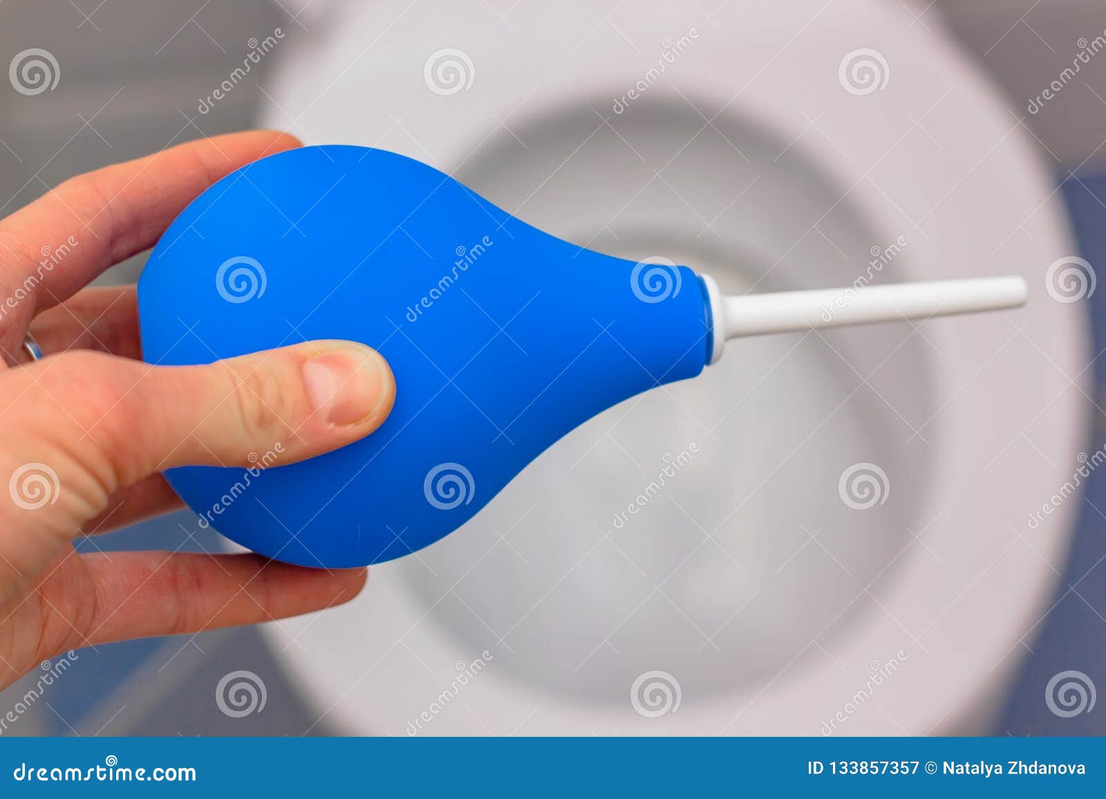 blue medical enema on the background of a white toilet