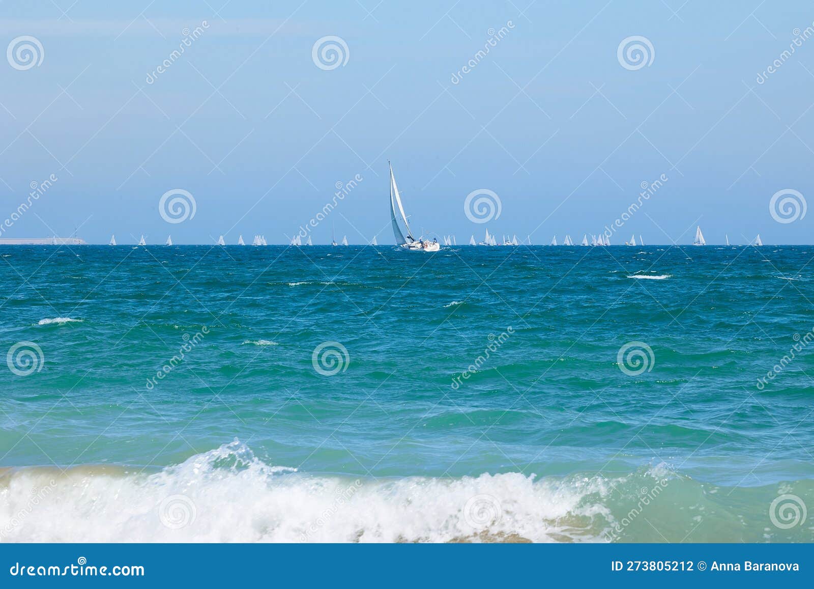 blue mediterranean sea, clear skies and a sailing ship with white sailing and a lot of sailboats. regatta