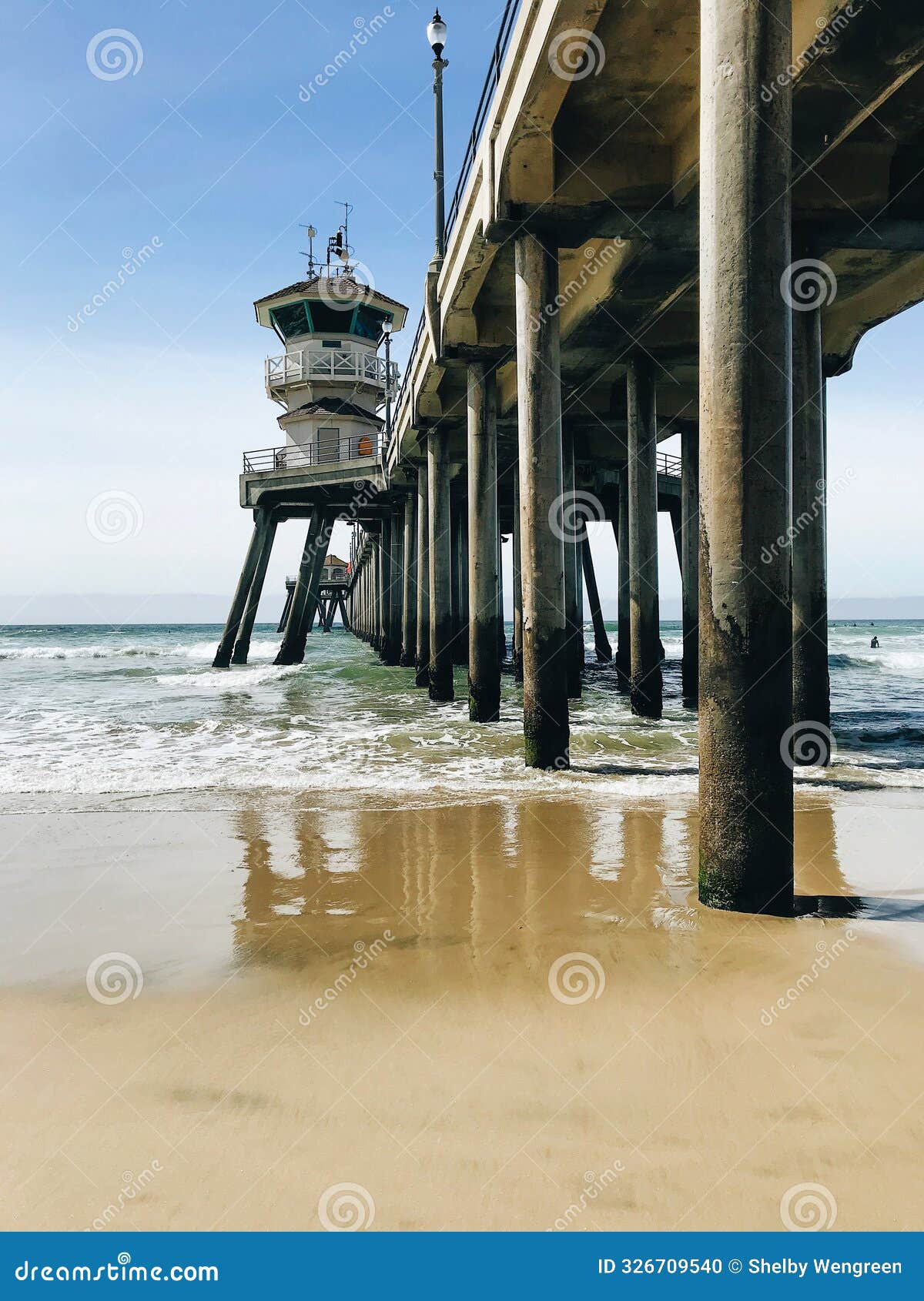 blue ocean waves crashing against huntington beach pier