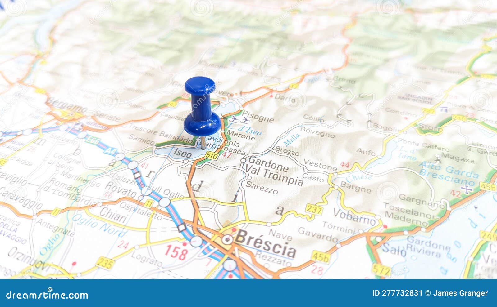 a blue pin stuck in lake iseo on a map of italy