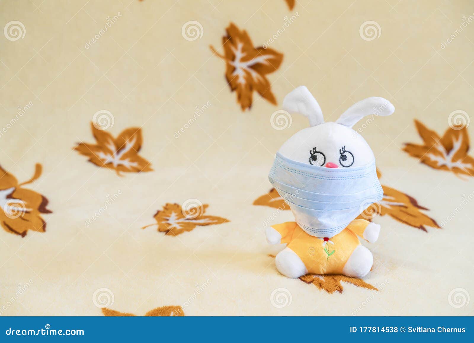 Blue Protective Face Mask on Soft Toy Bunny on Colored Background. Viruses Protection Concept