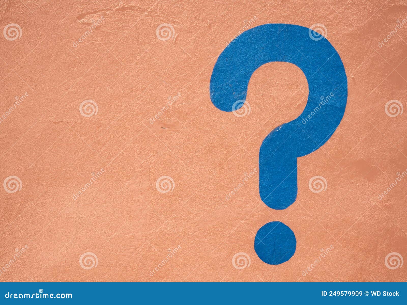 a blue question mark painted on a sand colored wall in morrocco