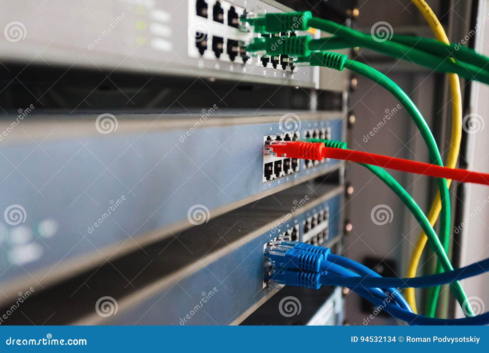 Blue, Red and Green Network Cables Connected To Switch Stock Photo
