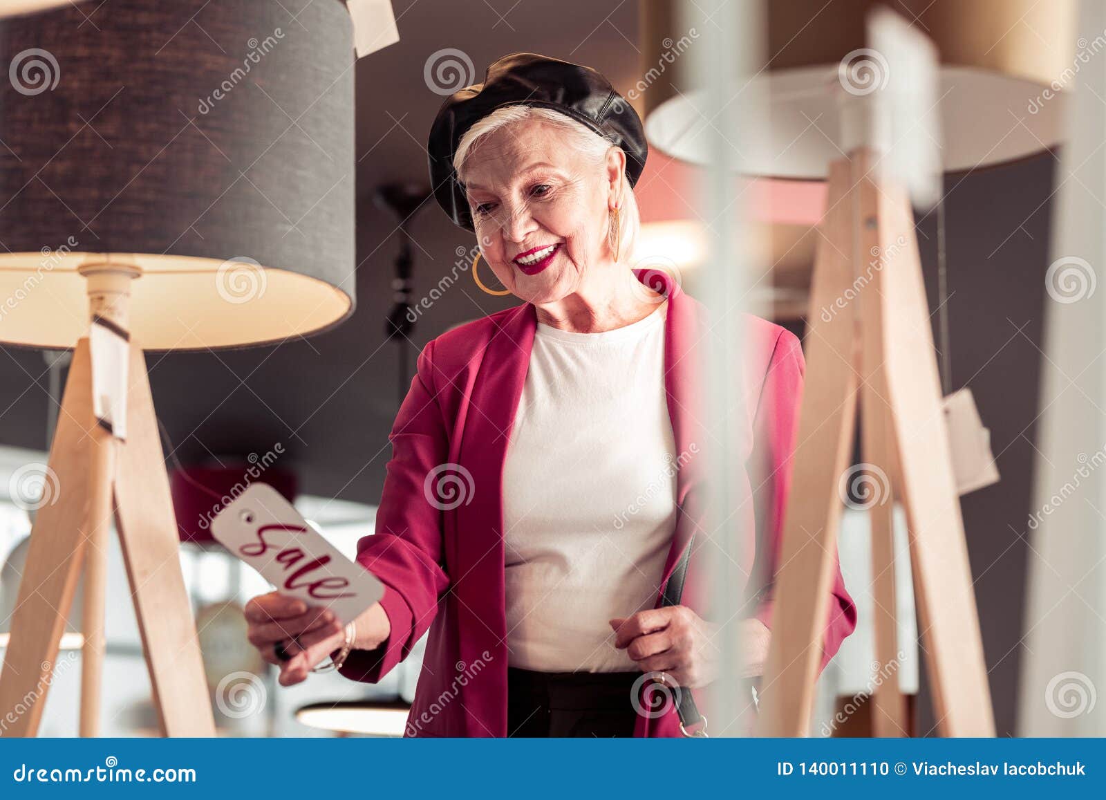 blue-rinsed charming elderly lady smilingly looking at sale sign