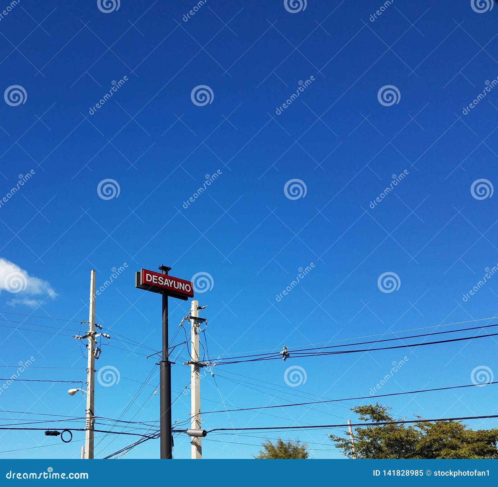 blue sky with cables and sign saying desayuno in spanish or breakfast