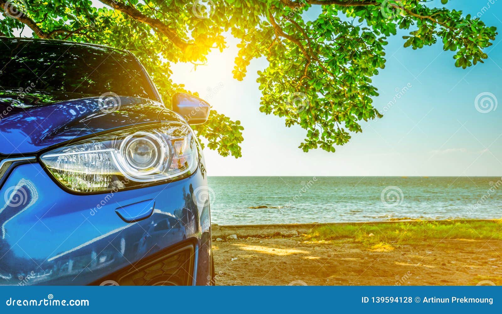 blue sport suv car parked by the tropical sea under umbrella tree. summer vacation at the beach. summer travel by car. road trip.