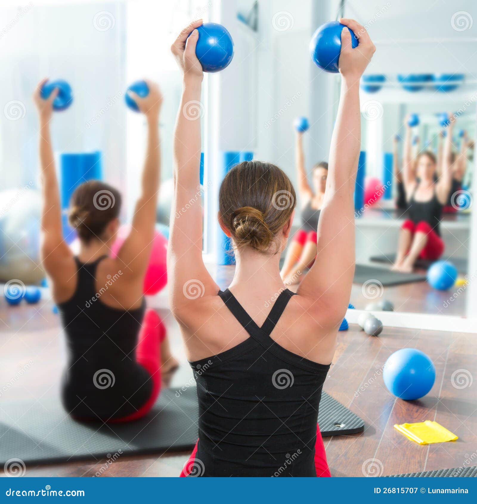 blue toning ball in women pilates class rear view