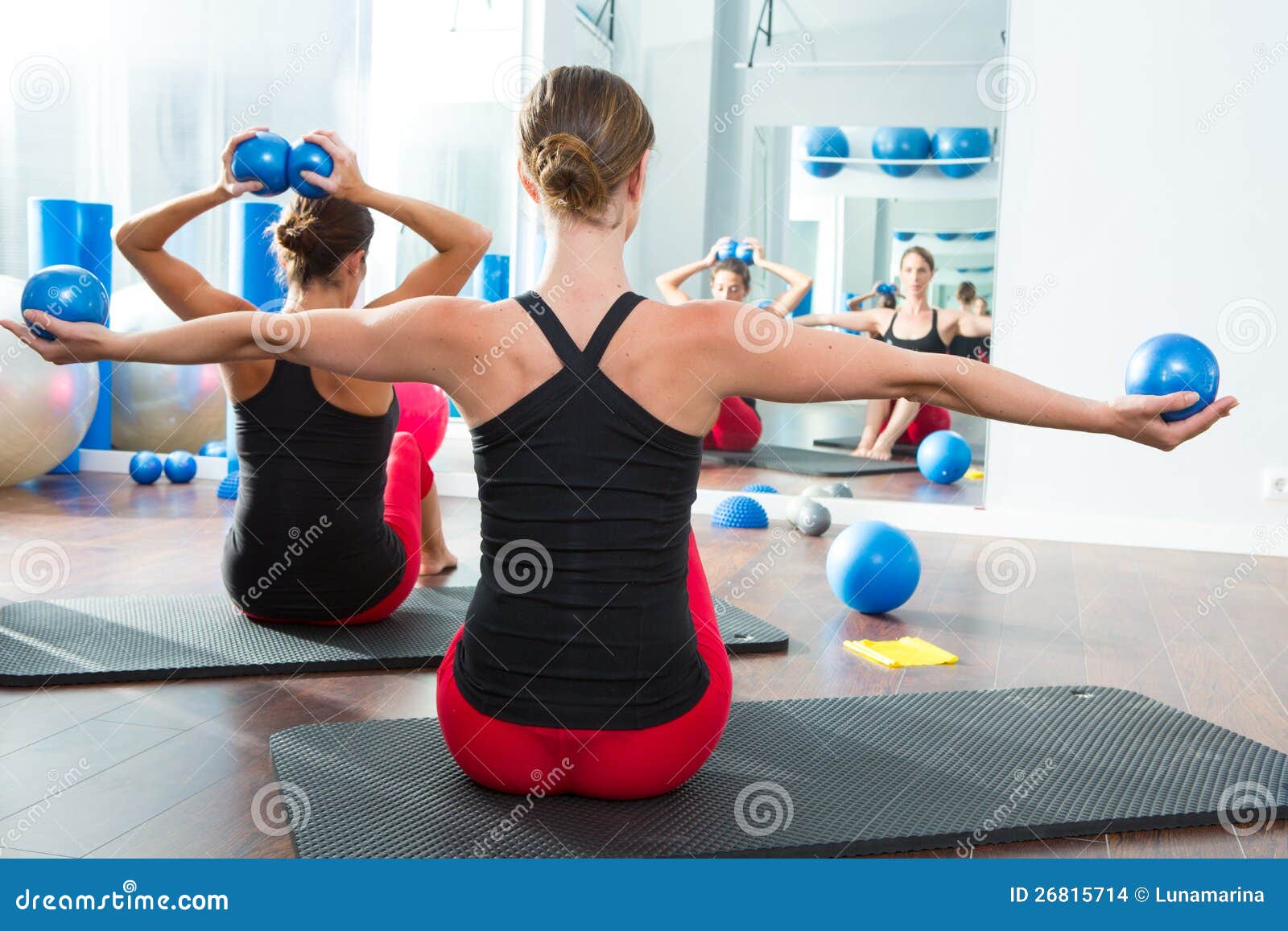 blue toning ball in women pilates class rear view