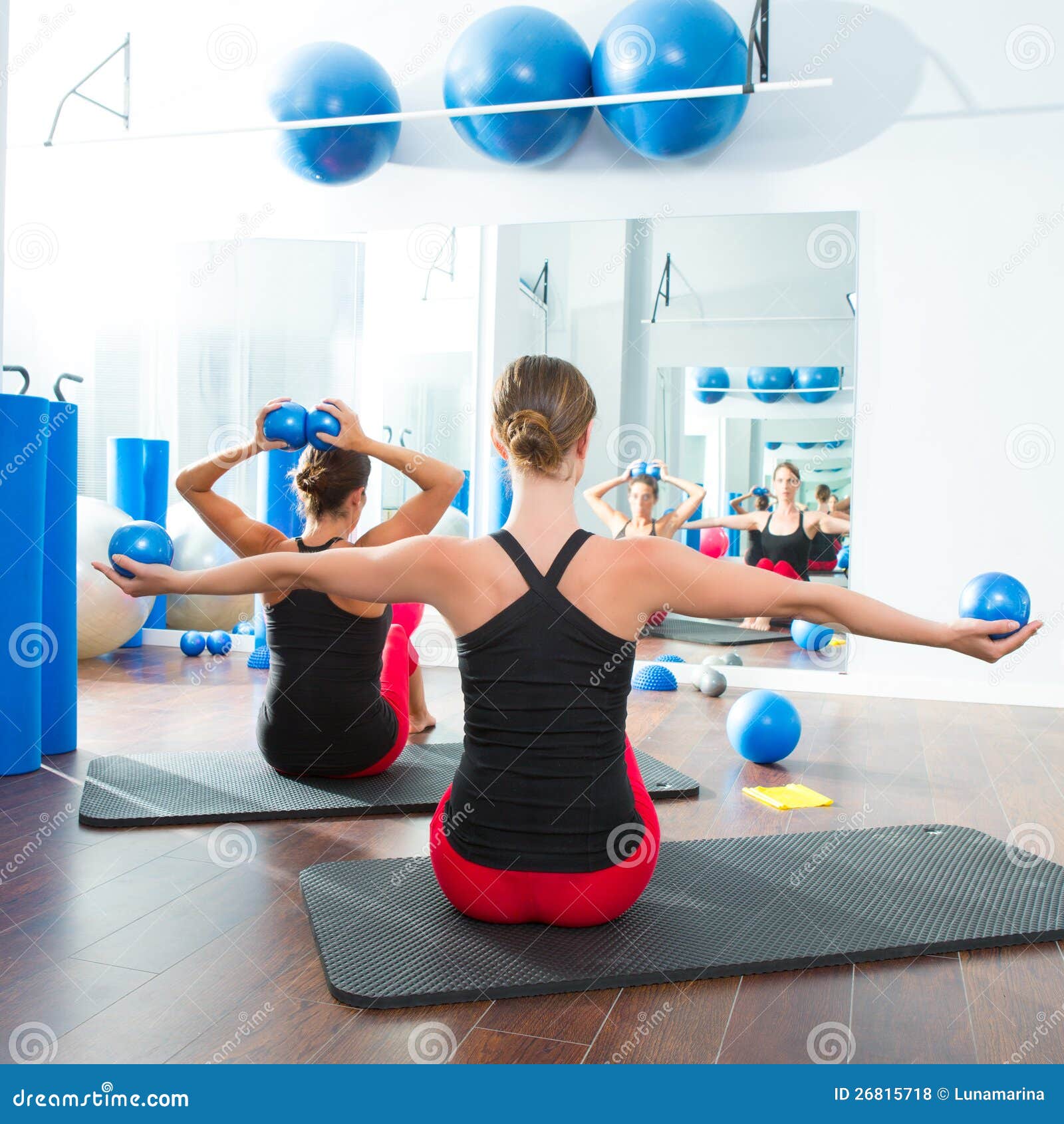 blue toning ball in women pilates class rear view
