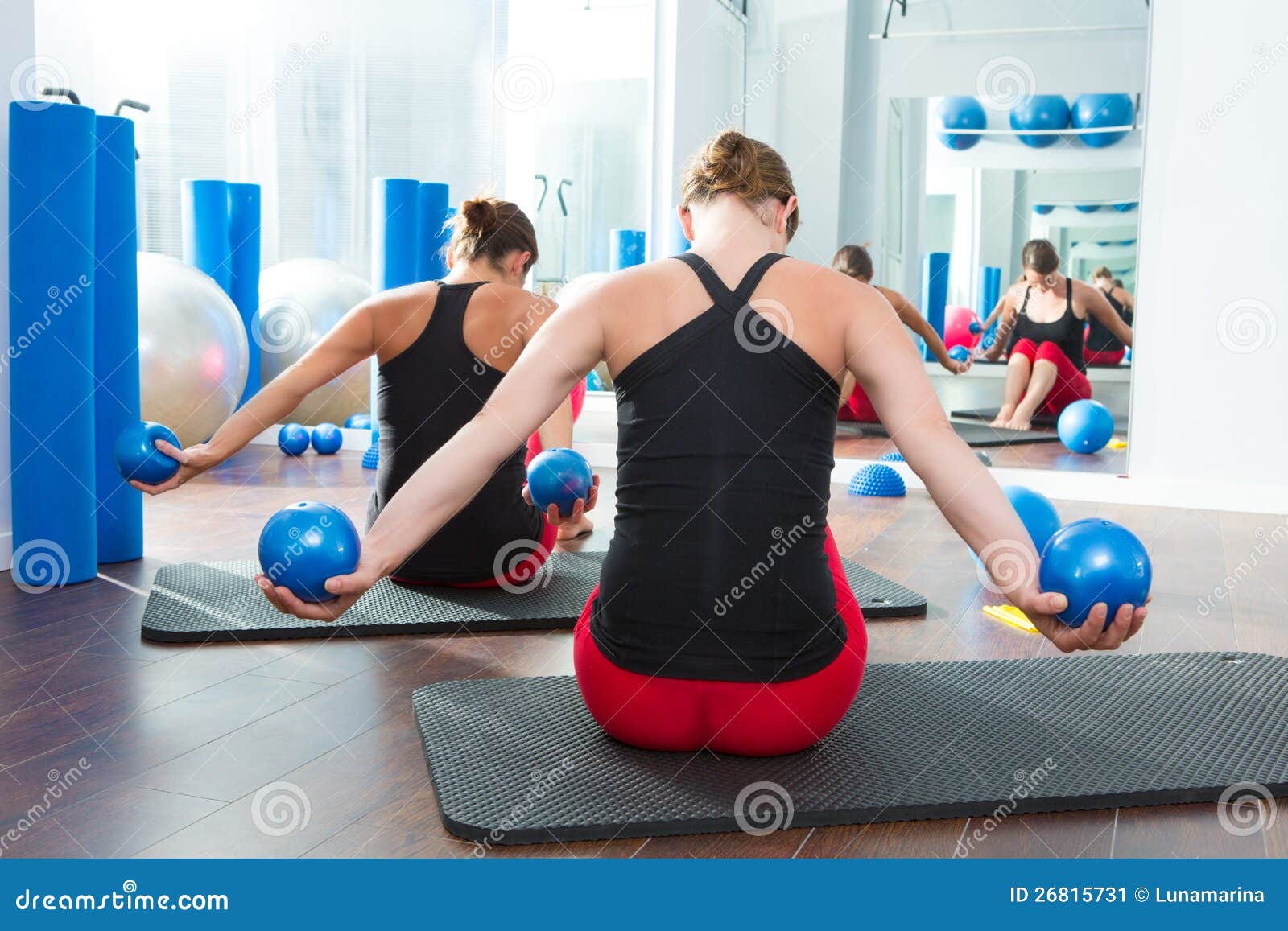 blue toning ball in women pilates class rear view