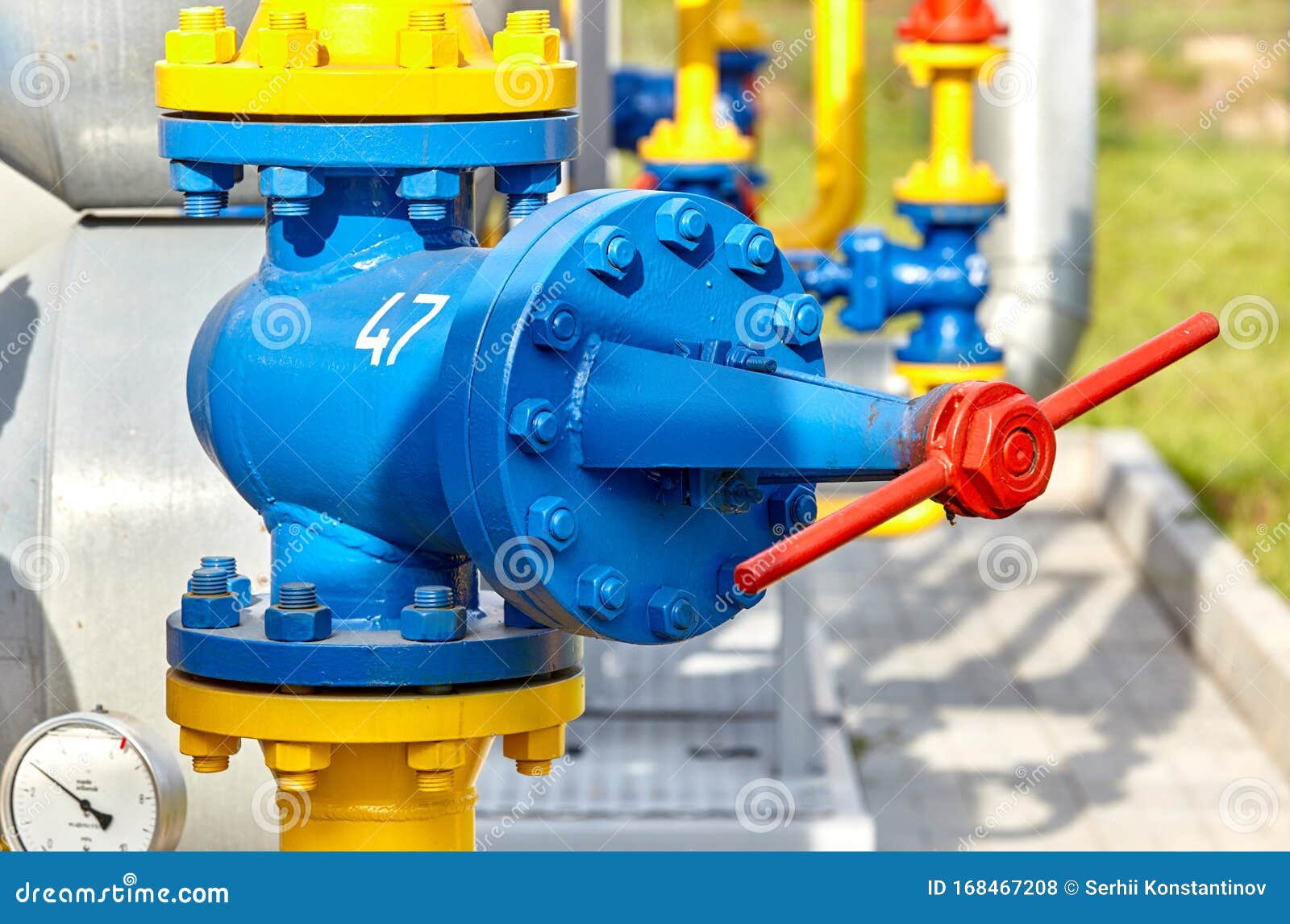 Blue Valve on a Yellow Pipe at a Gas Processing Plant Stock Photo