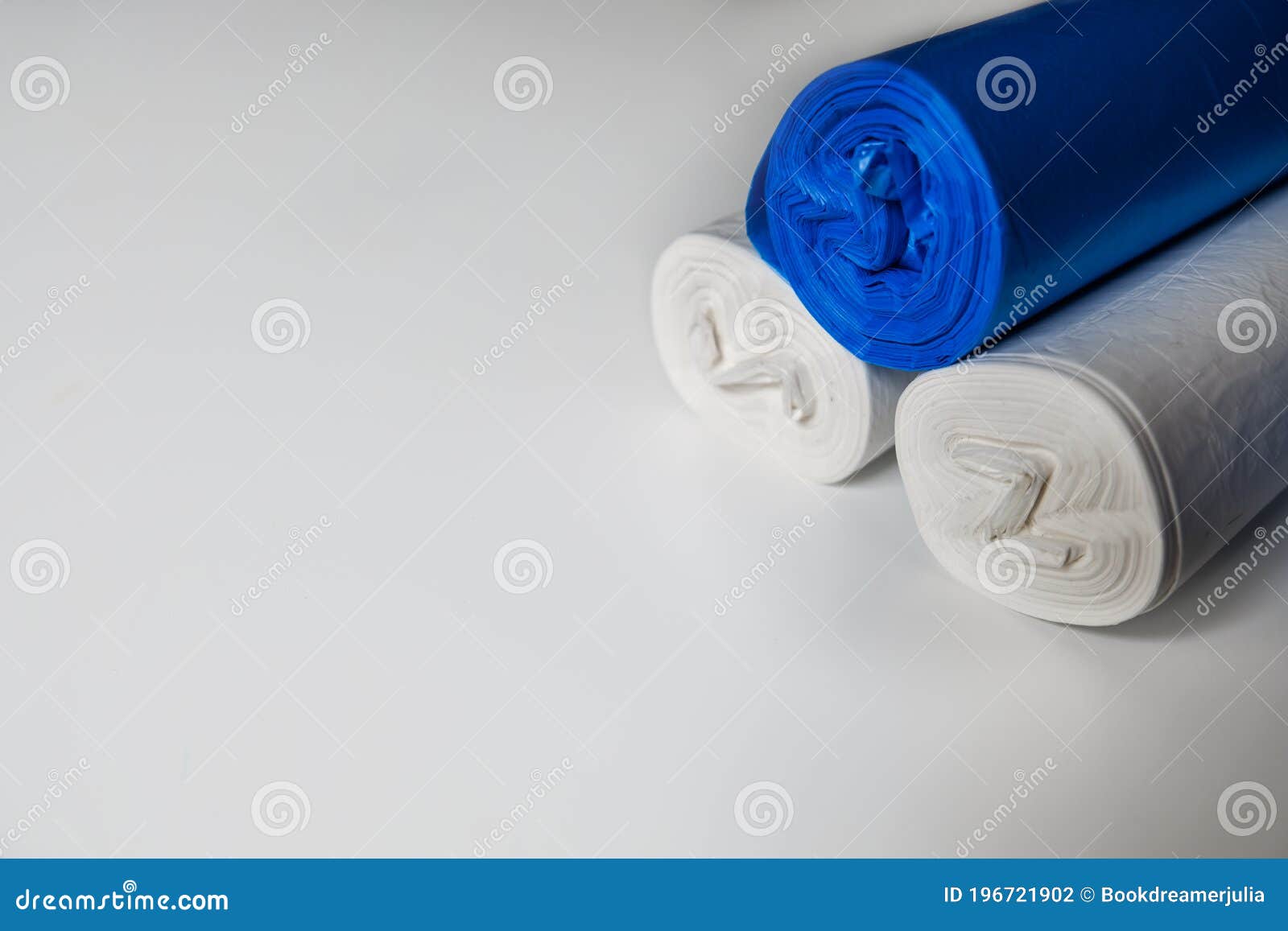 Blue and White Plastic Trash Bags on a White Surface. Recyclable