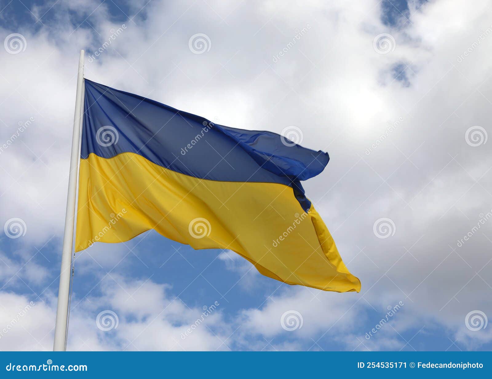 Blue and Yellow Flag of Ukraine with Blue Sky and Clouds Stock Image