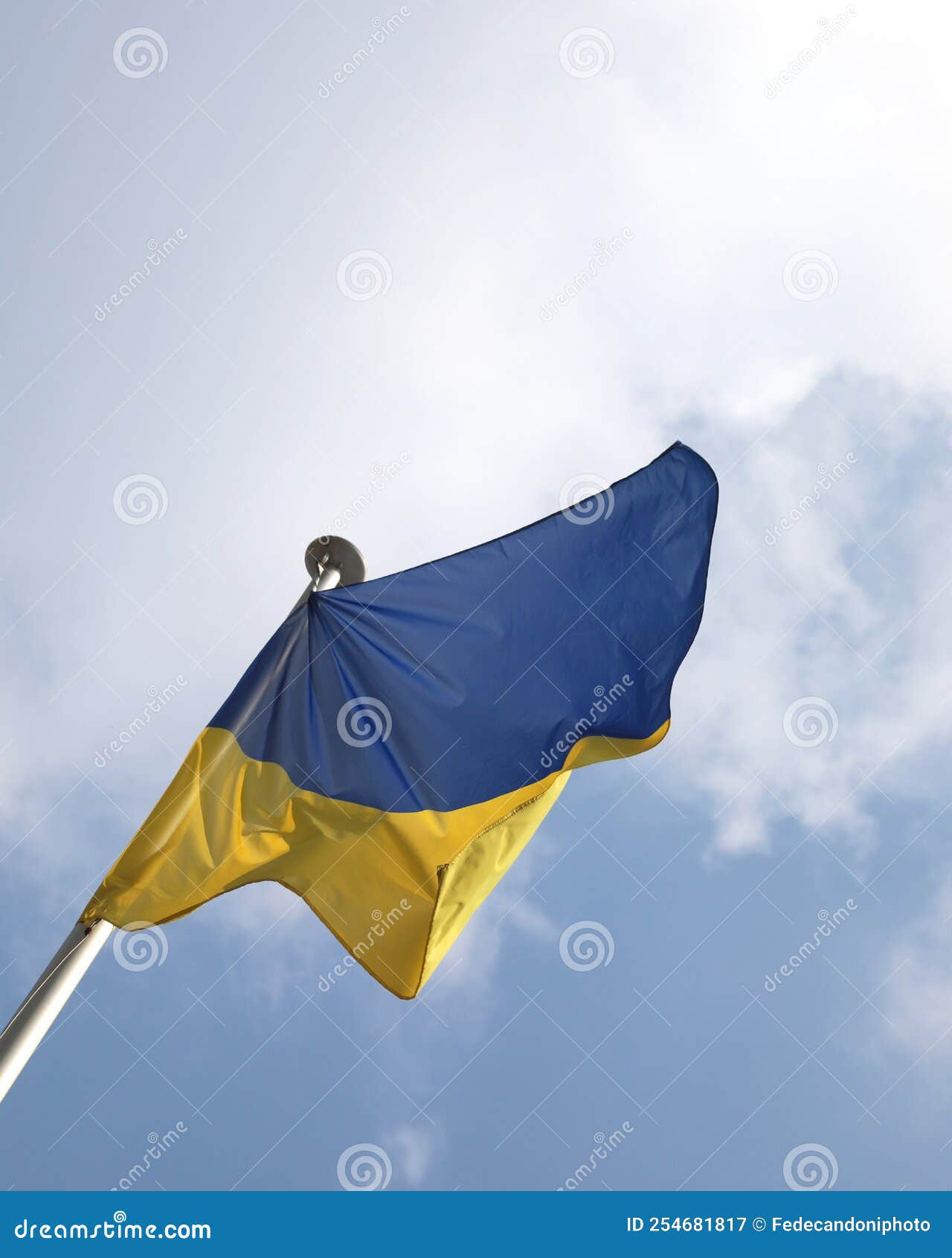 Blue and Yellow Flag of Ukraine with Blue Sky and Clouds Stock Image