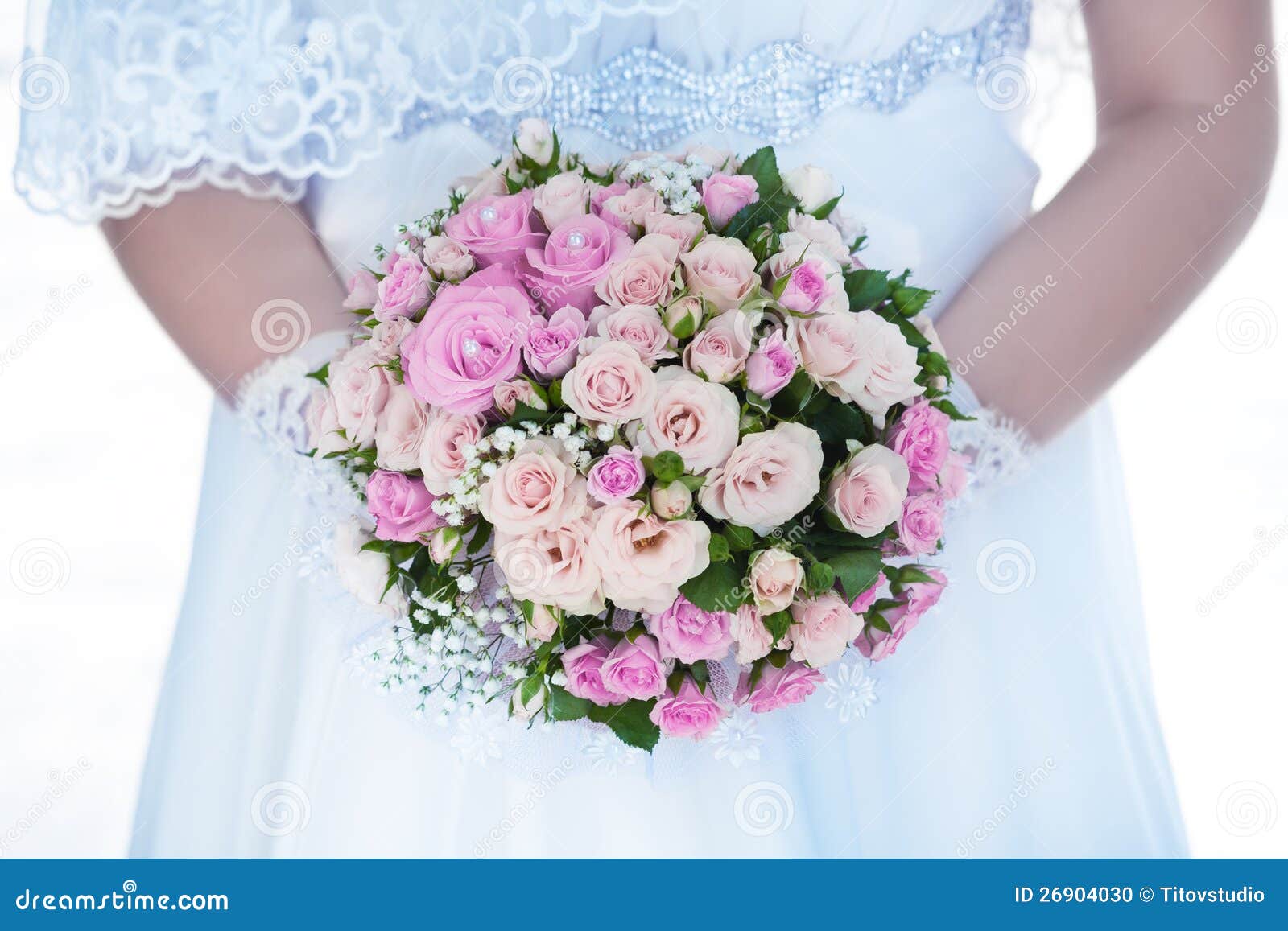 Blumenstrauß der rosafarbenen Rosen in den Händen der Braut. Blumenstrauß der Blumen und des Hochzeitskleides