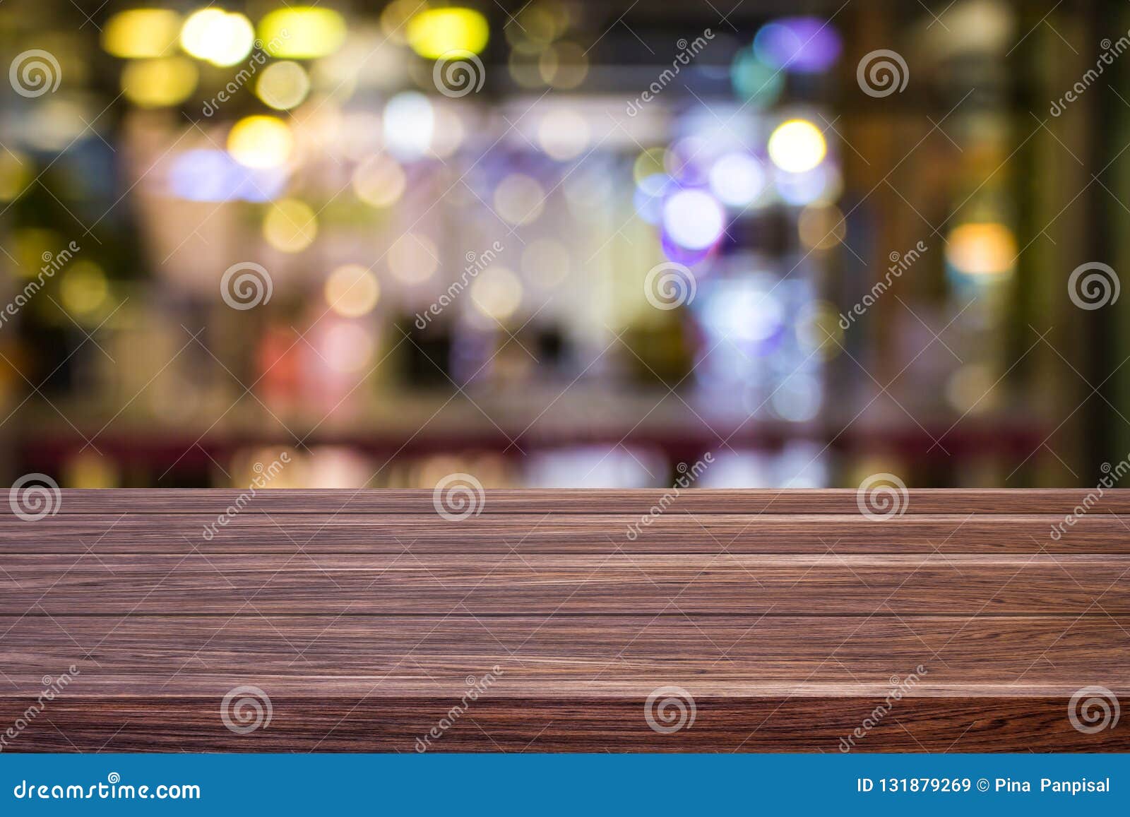 blur cafe restaurant or coffee shop empty of dark wood table with blurred light gold bokeh abstract background for montage product