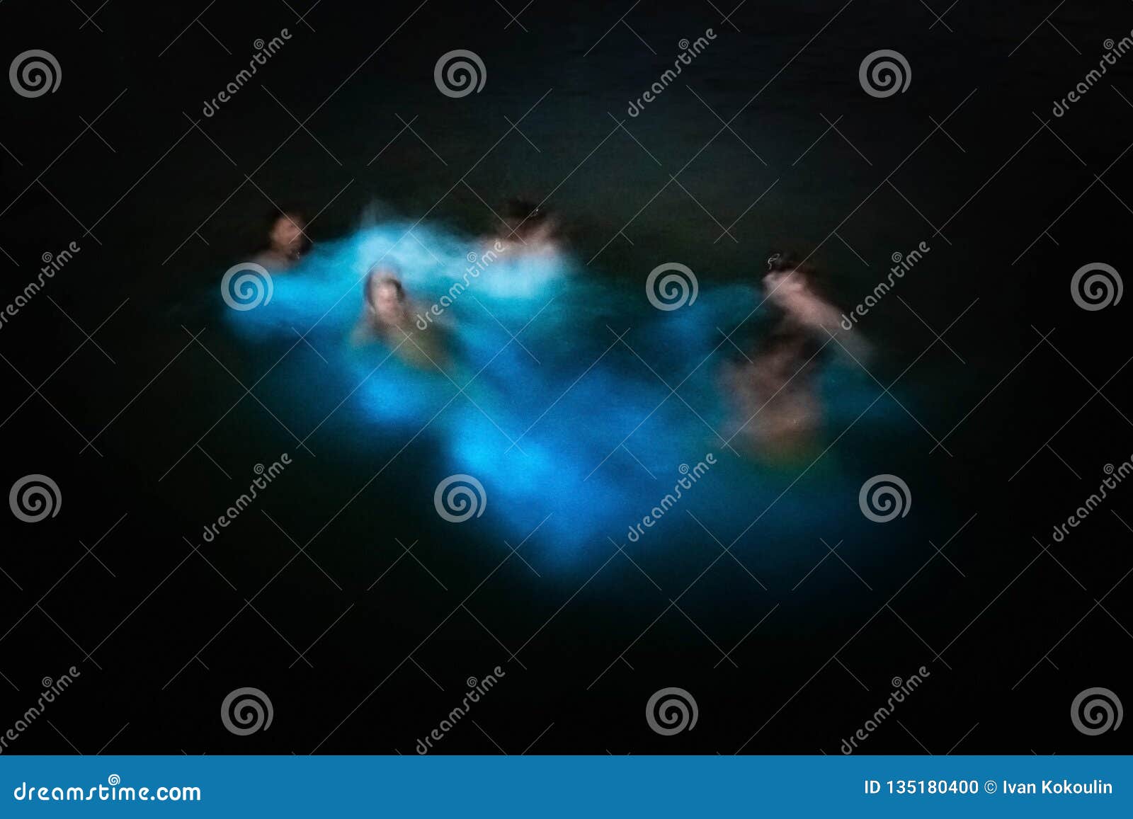 blurred group of people swimming in glowing waters