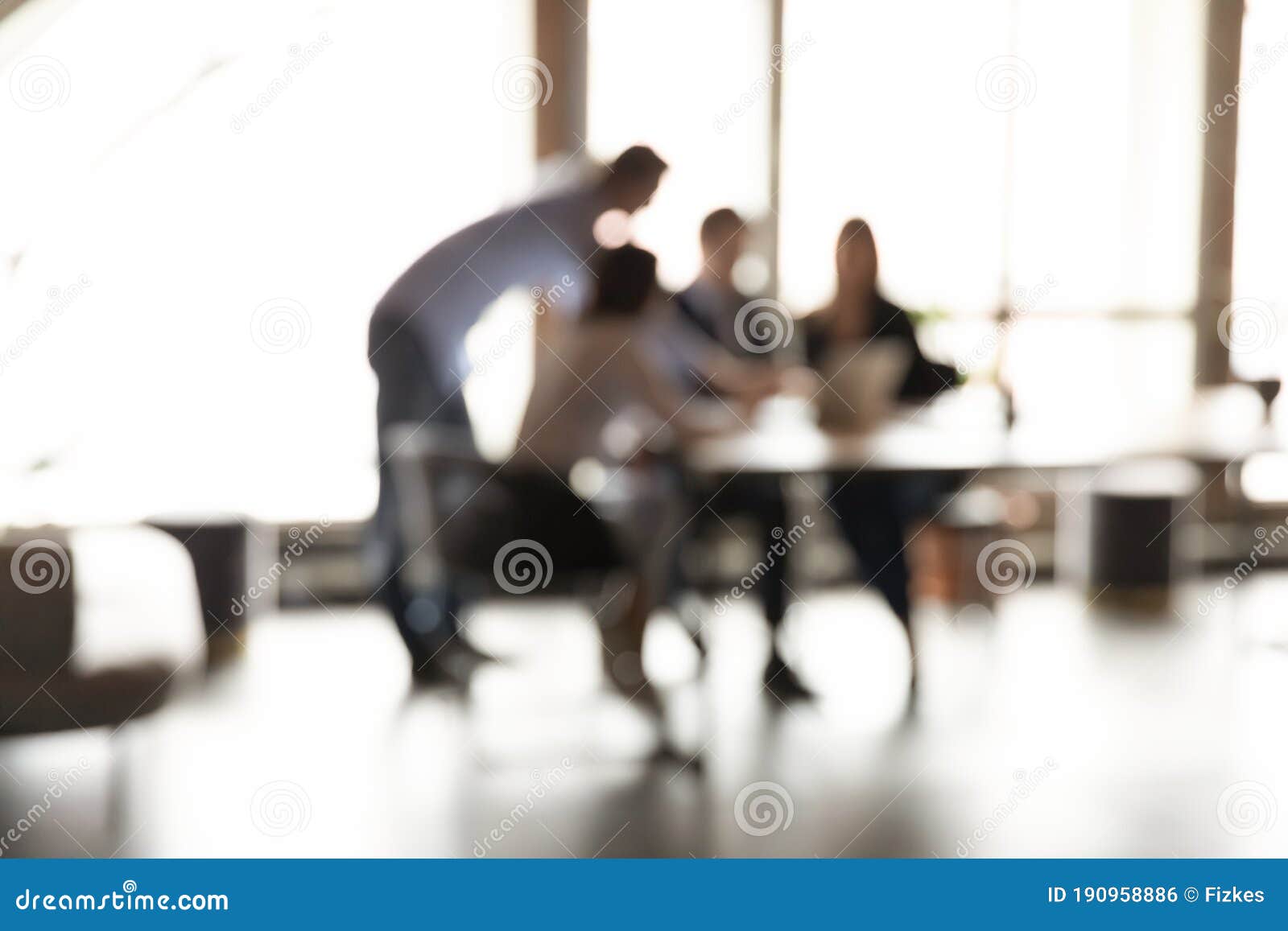 blurry view of colleagues work together on project in office