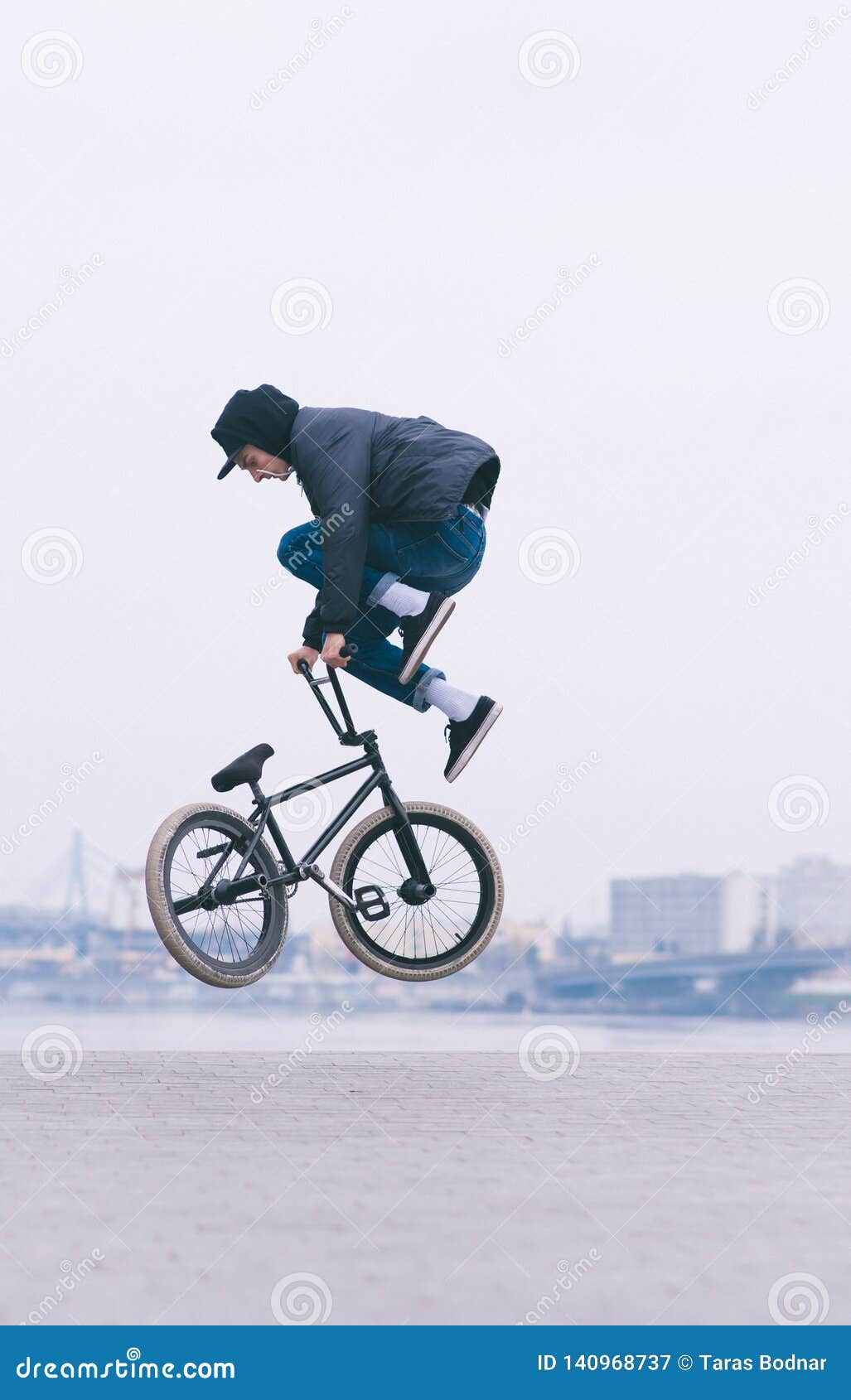 Young Man Makes an Air Tricks on a BMX Bike. Against the Background of the  Urban Landscape Stock Image - Image of jump, bicycle: 140968737