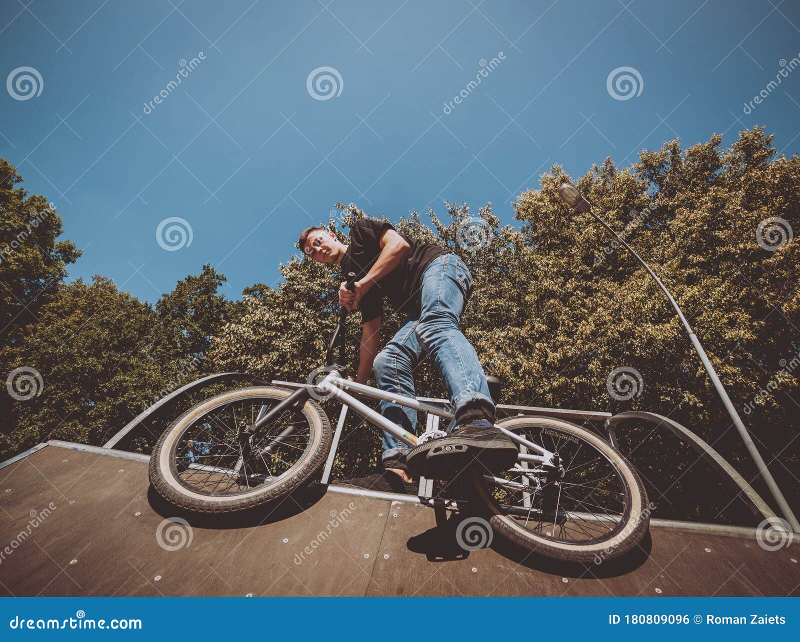 Bmx Rider Performing Tricks at Skatepark. Background. Stock Photo