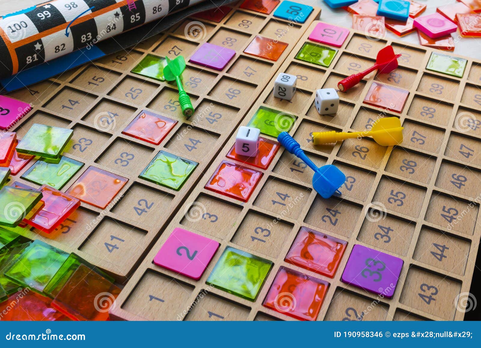 a board game board, wooden blocks, toy arrows, and dice lying on the floor.