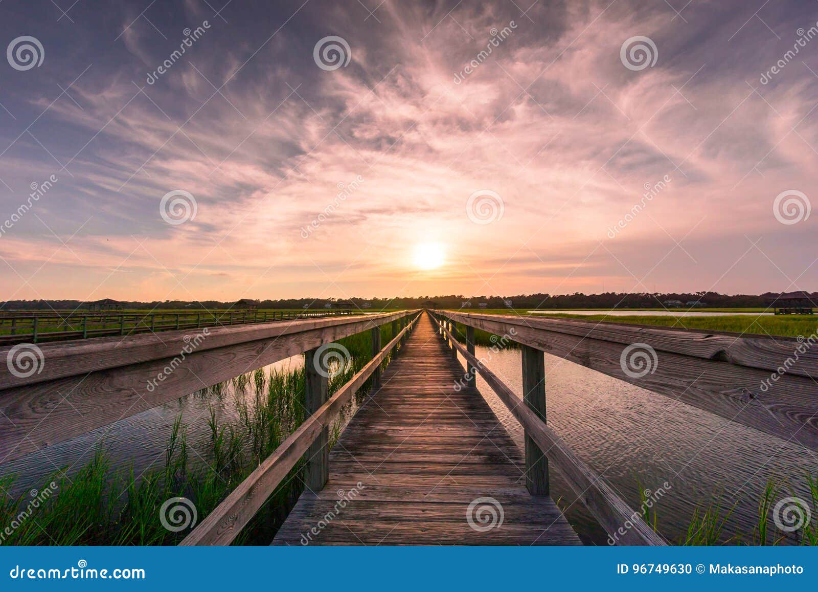 boardwalk over salt marsh at sunset
