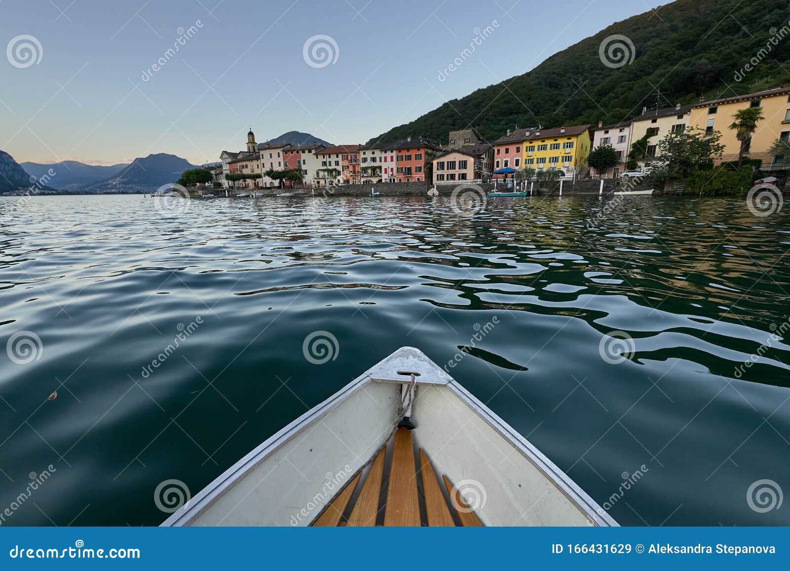 a boat bobs on the waves of a lake in switzerland, approaching the coastline