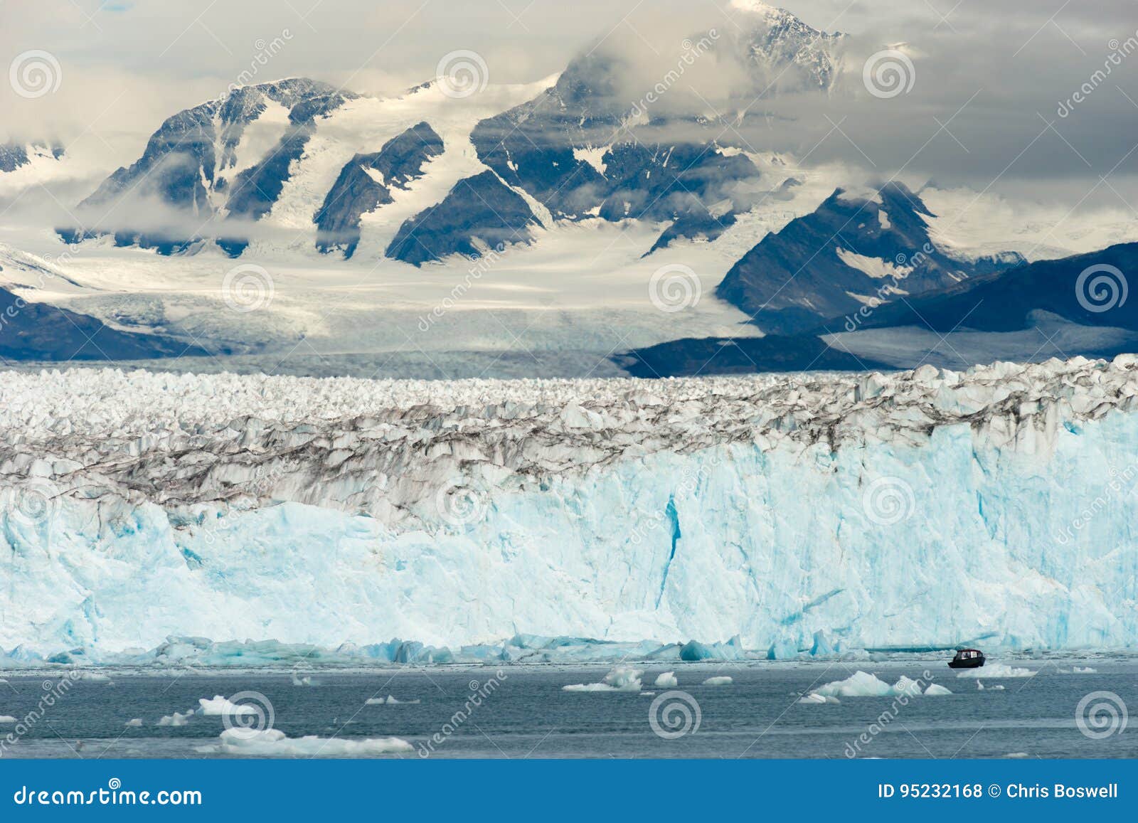 boat dwarfed by mountains glaciers alaska kenai fjords