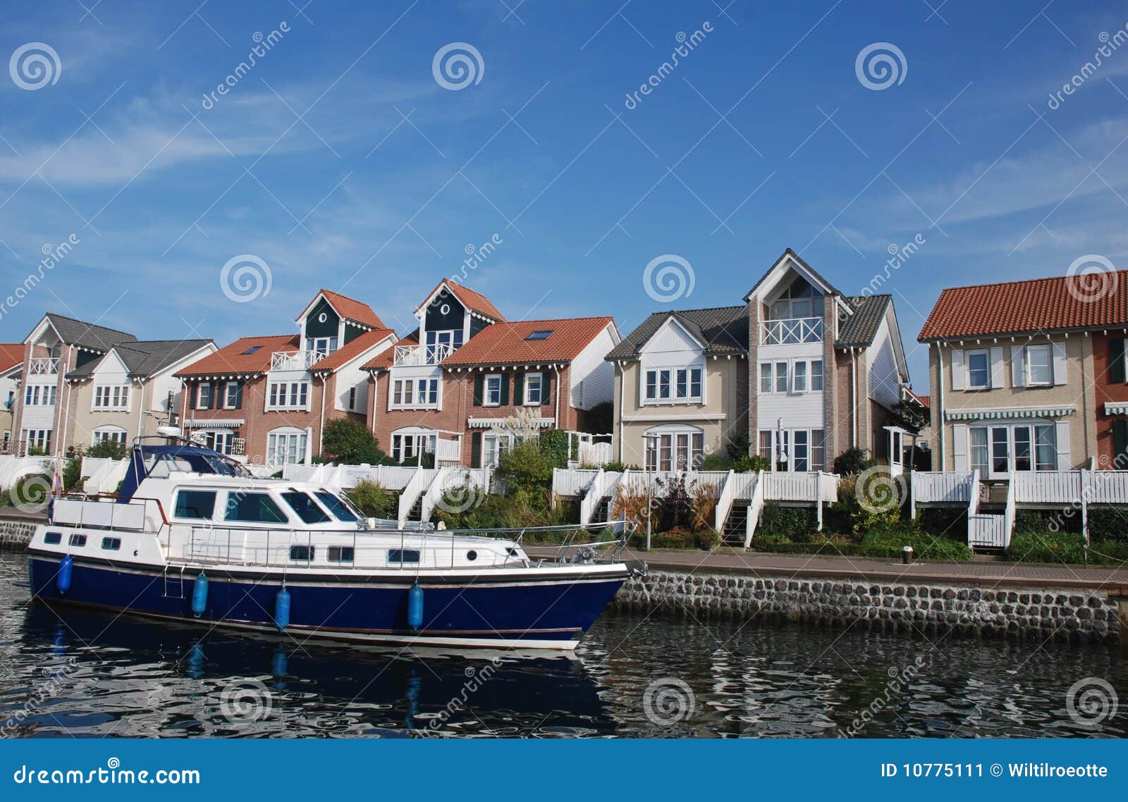 Boat sails past houses. Boat sails past modern houses with waterfront view