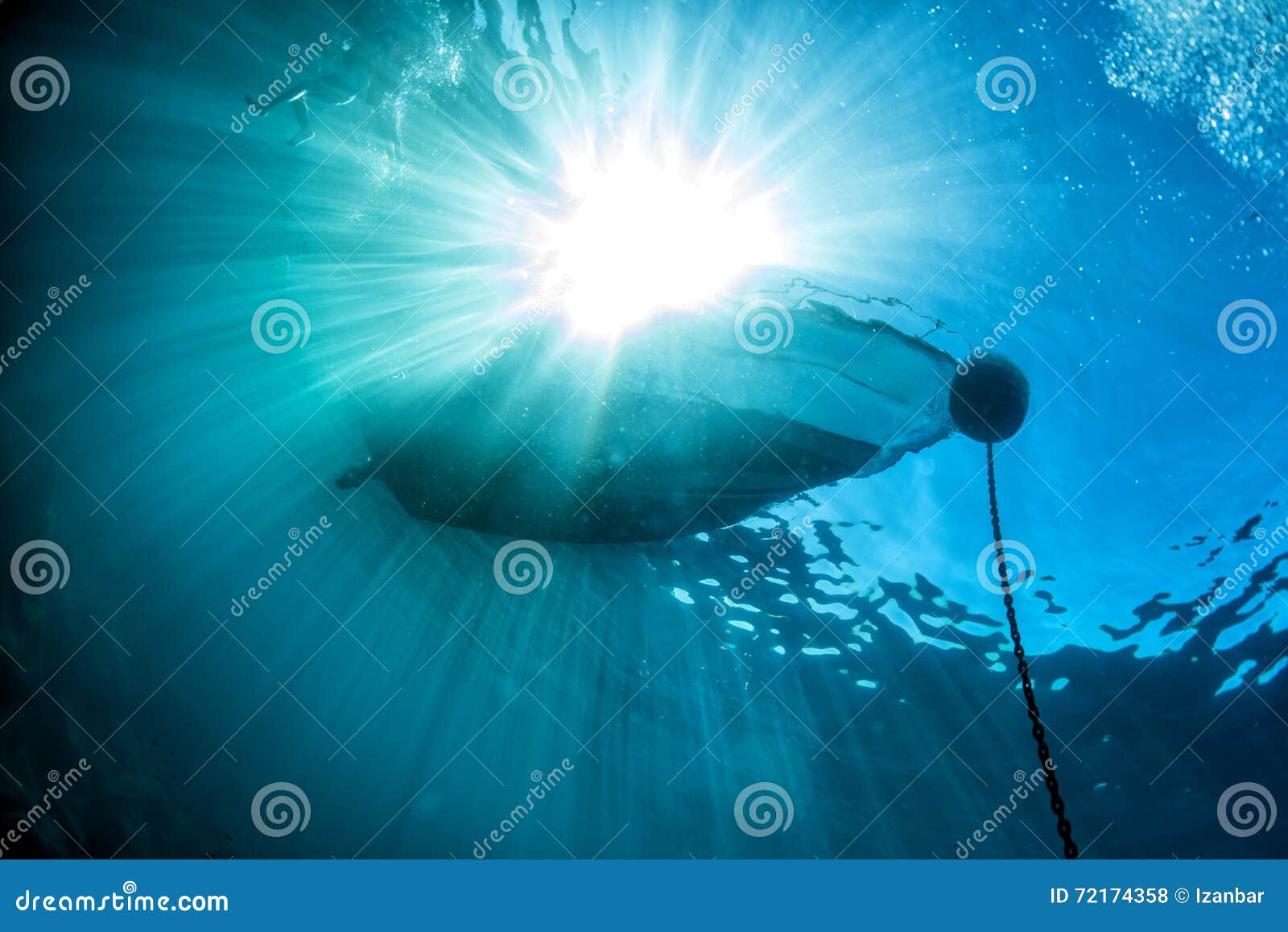 Boat Ship from Underwater Blue Ocean with Sun Rays Stock Photo