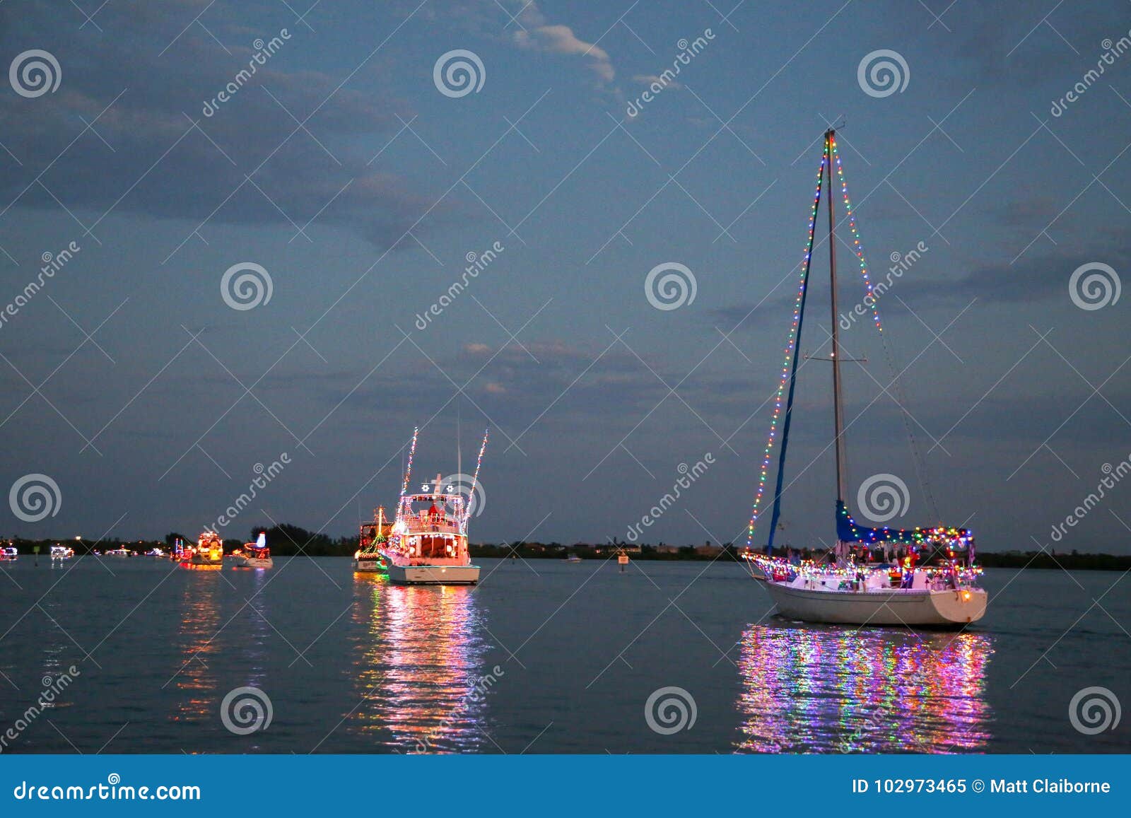 power and sailboats participate in a holida boat parade