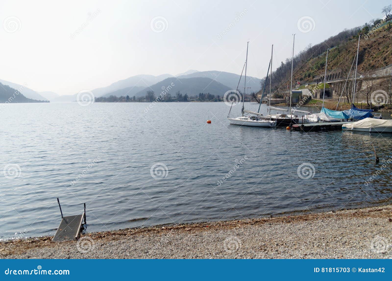 boats on the shore of lago di lugano, switzerland