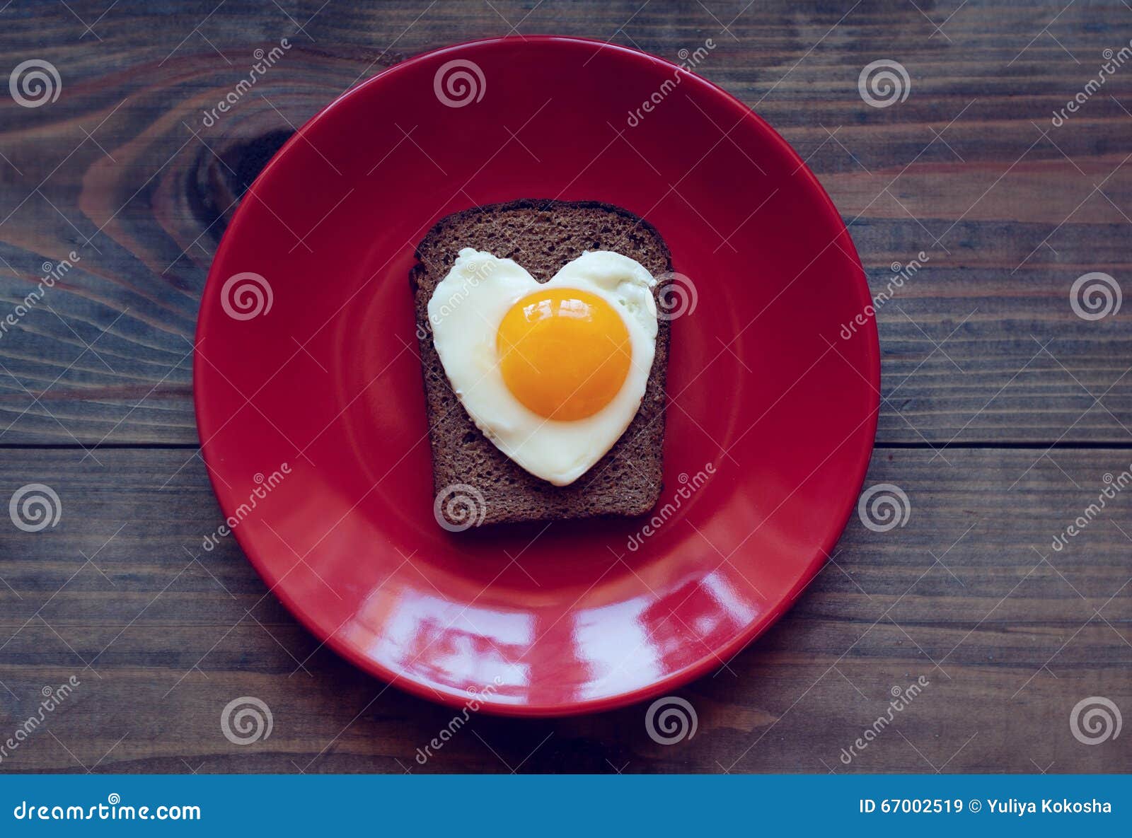 Bocadillo del pan de centeno con los huevos revueltos bajo la forma de corazón. Bocadillo con los huevos revueltos bajo la forma de corazón