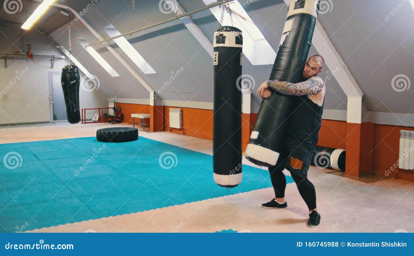 The Bodybuilder is Raising a Punching Bag Stock Photo Image of
