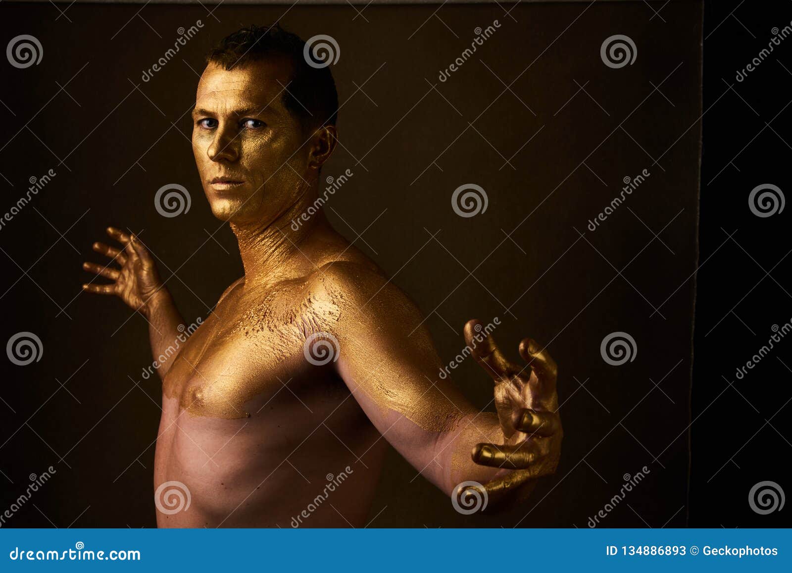 Body Art Paint with Gold on Face of Man Over Dark Background Stock