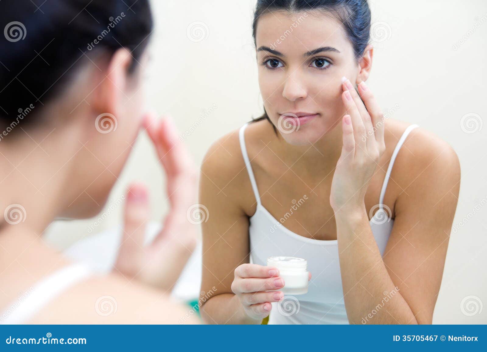 body care. woman applying cream on face