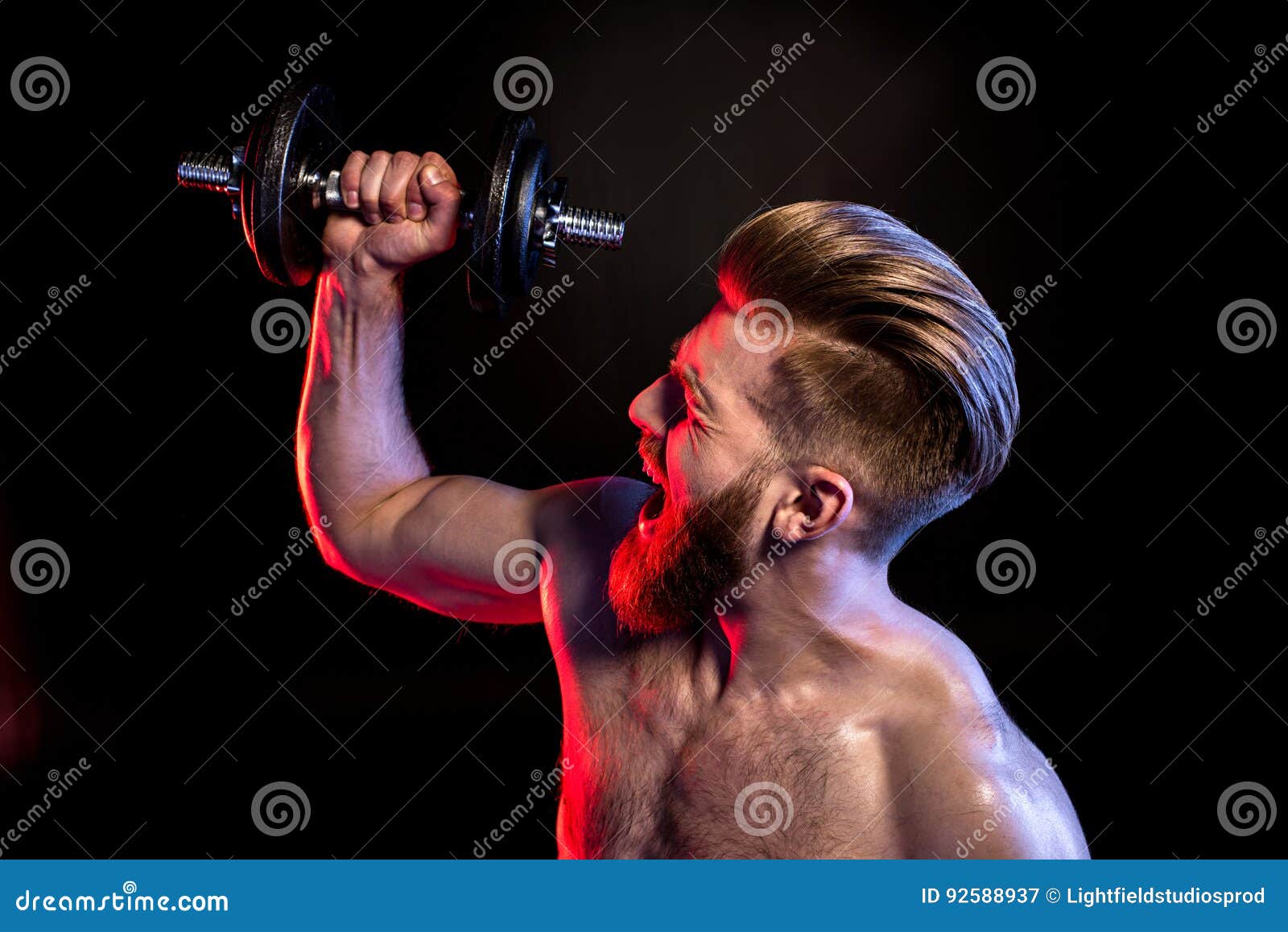 Bodybuilder Training with Dumbbell Isolated on Black with Dramatic