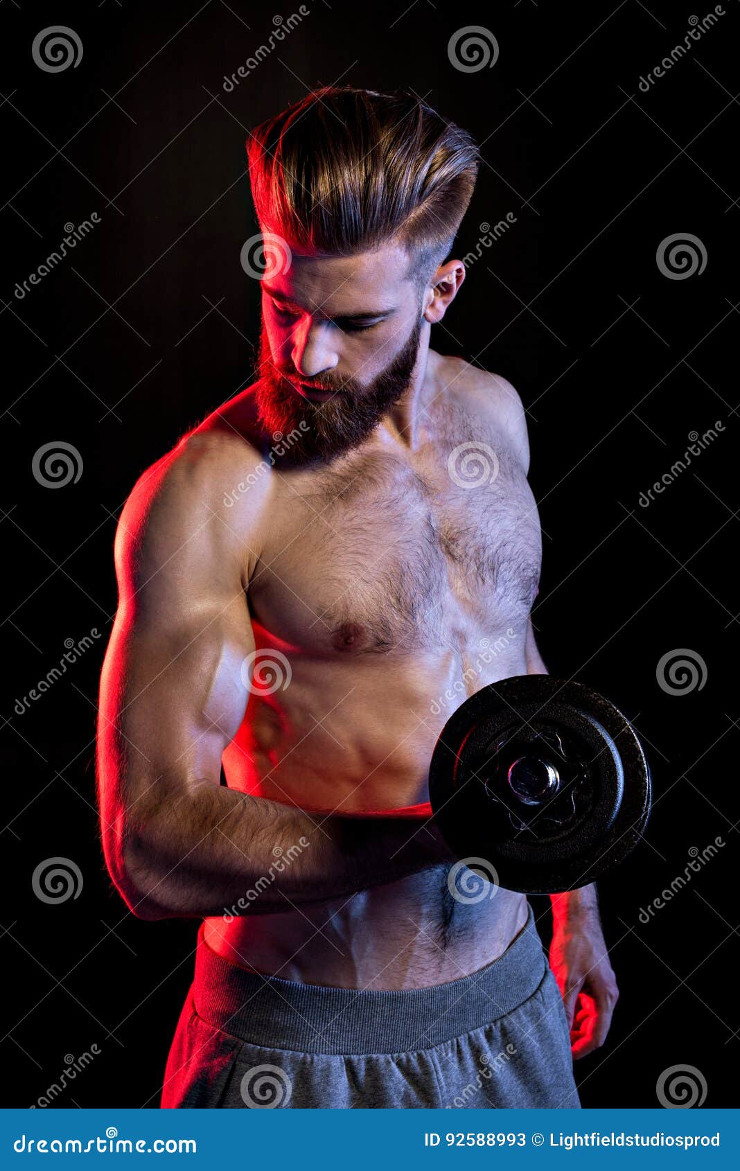 Bodybuilder Training with Dumbbell Isolated on Black with Dramatic