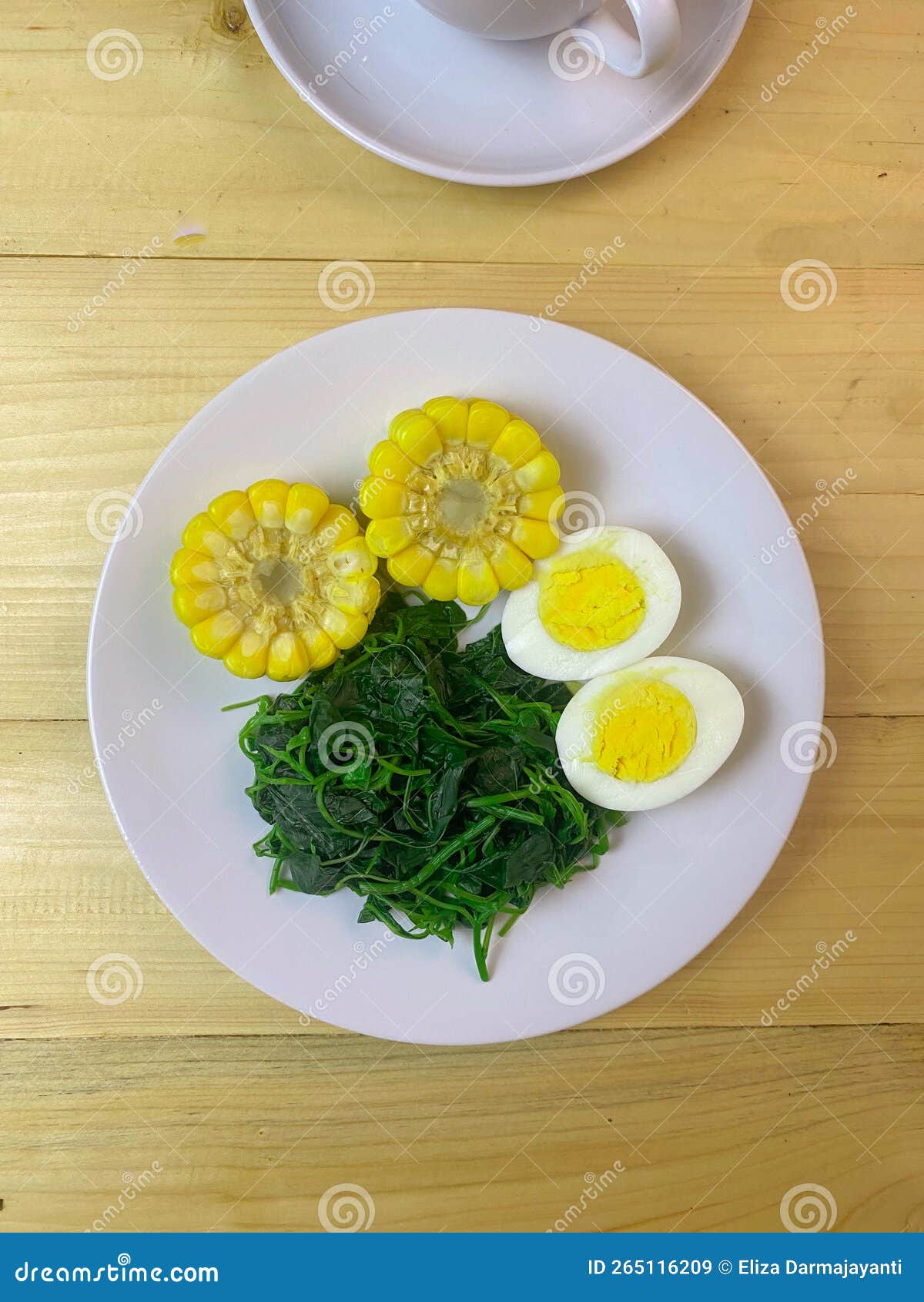 Boiled Corn, Boiled Spinach, and Boiled Egg are Served on the Plate