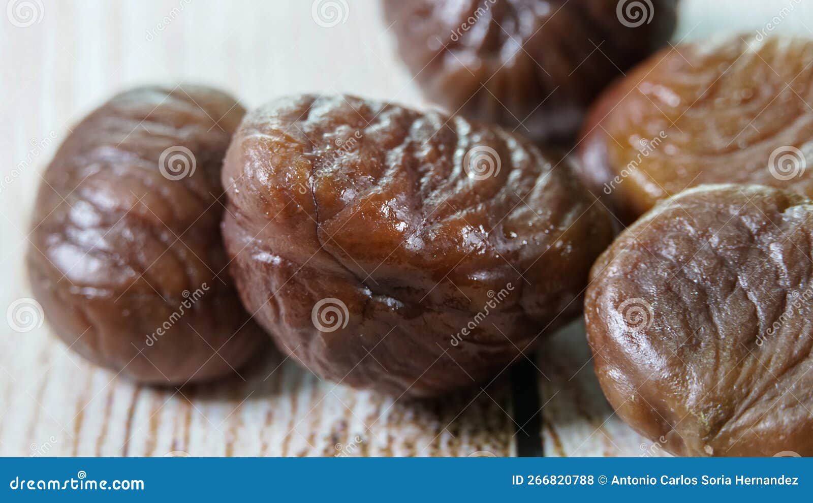 boiled and peeled chestnuts , closeup studio macro photo on white wooden table