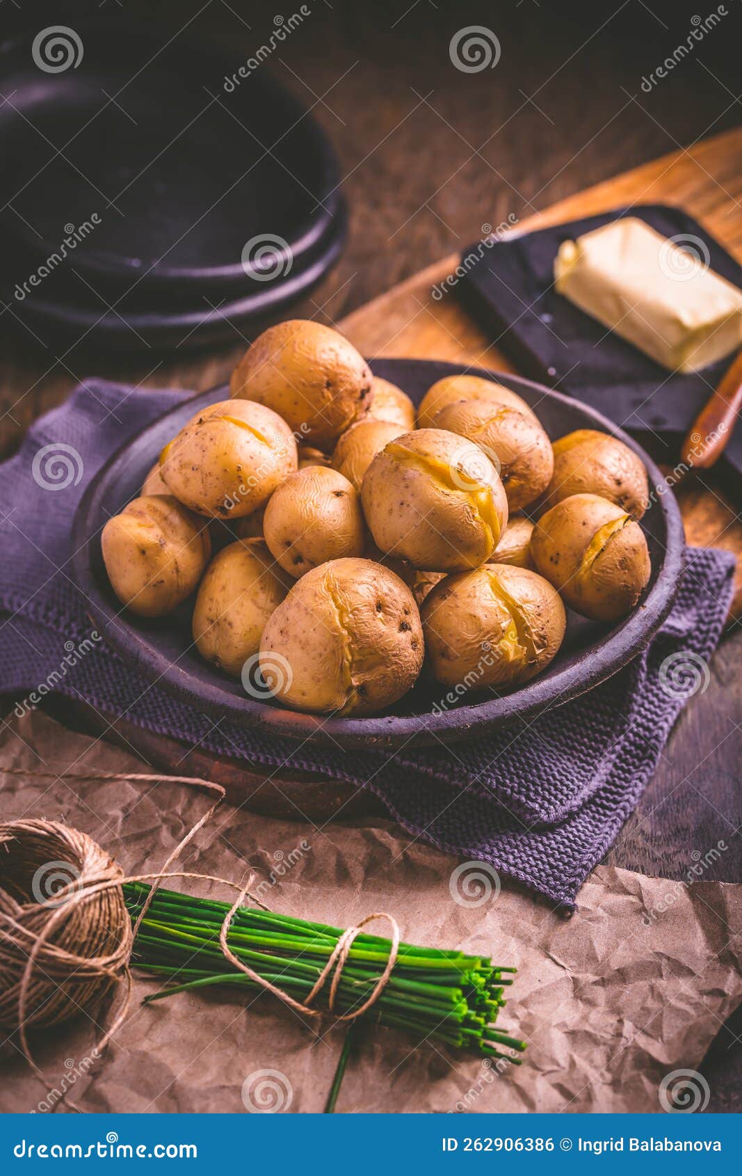 Boiled Young Potatoes with Butter and Chives on Cutting Board Stock