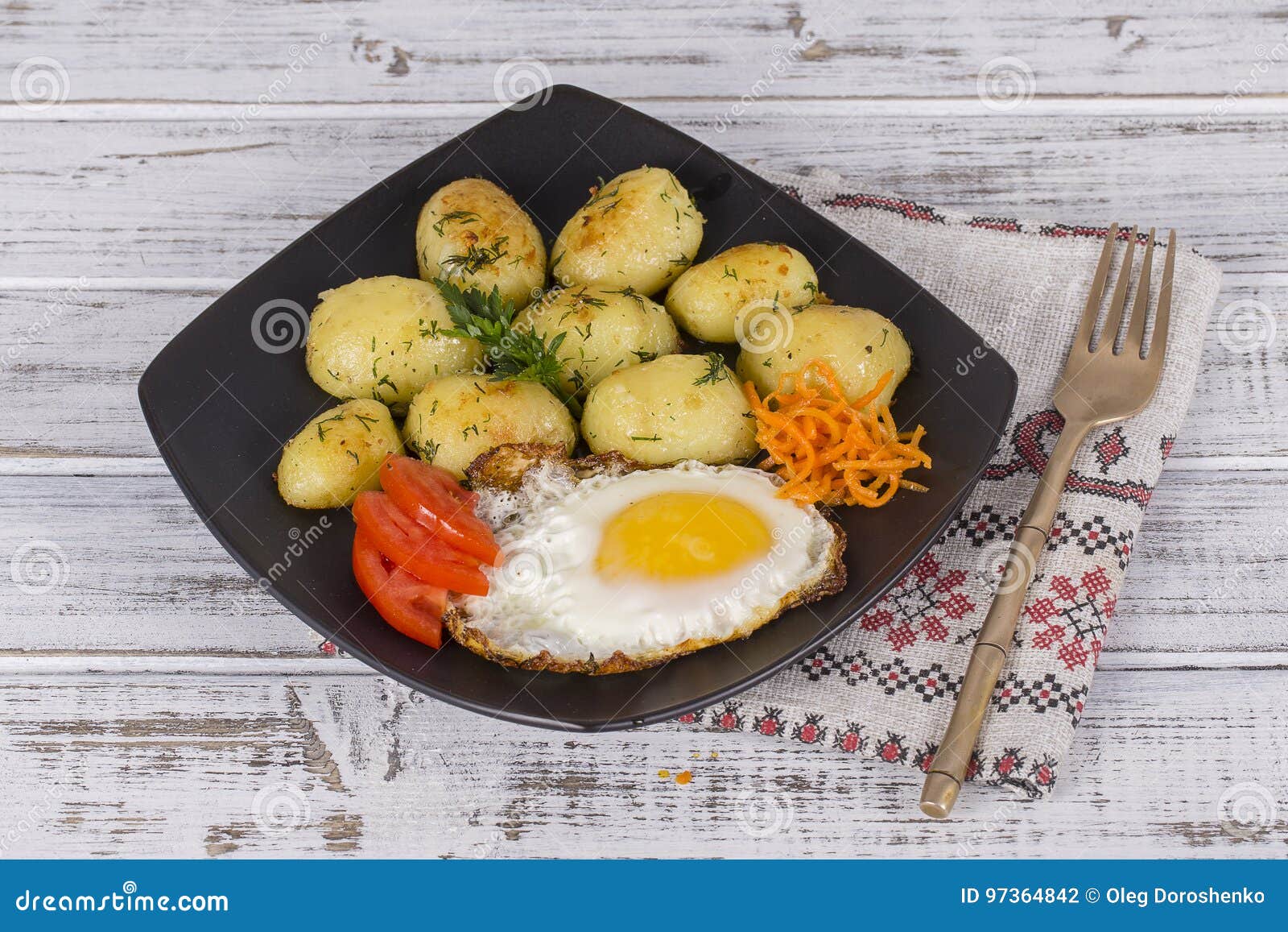Boiled Young Potatoes with Fried Eggs, Carrot and Tomato. Close Up