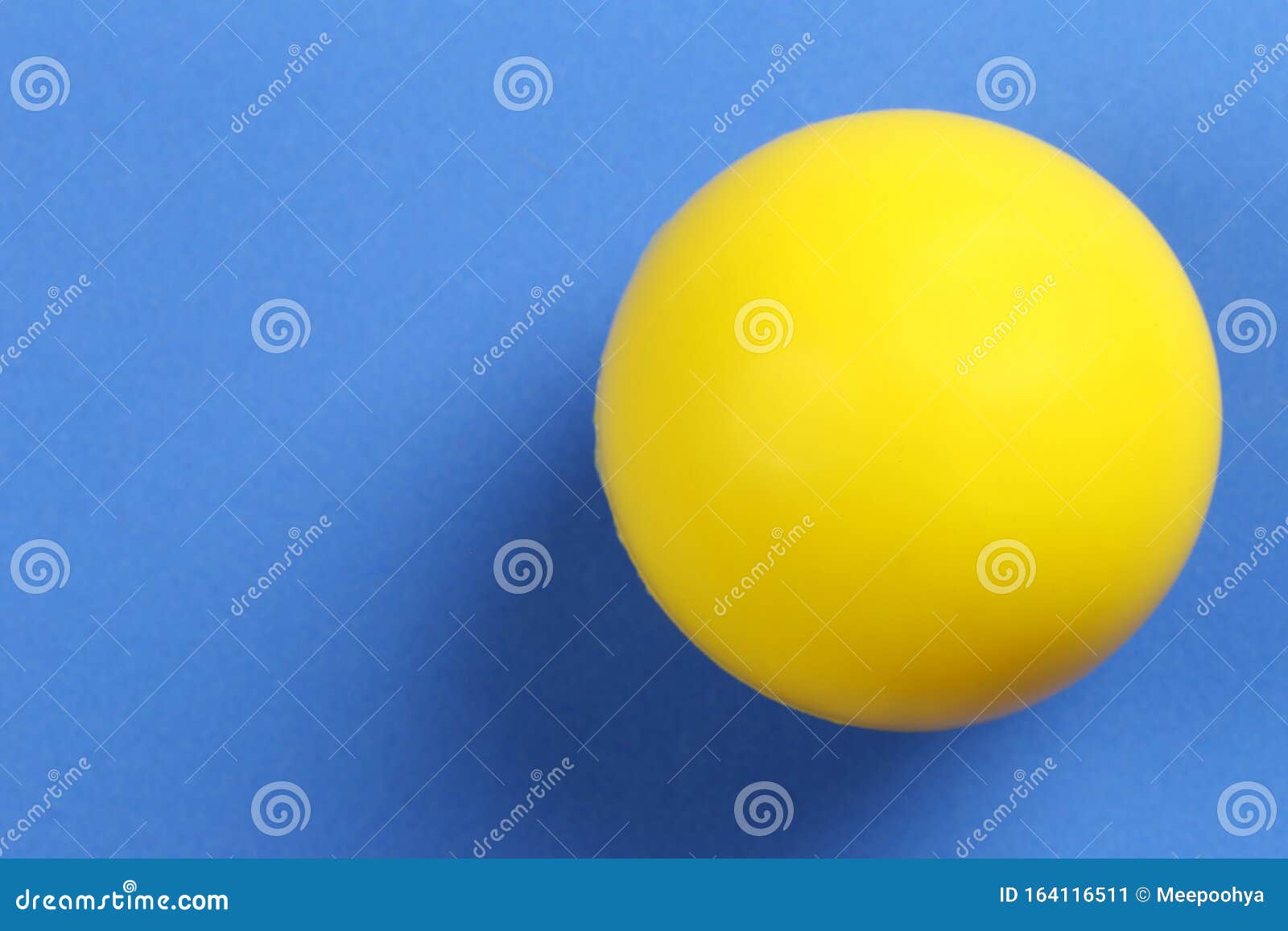 A Bola Amarela é Colocada Sobre Um Fundo Azul Imagem de Stock