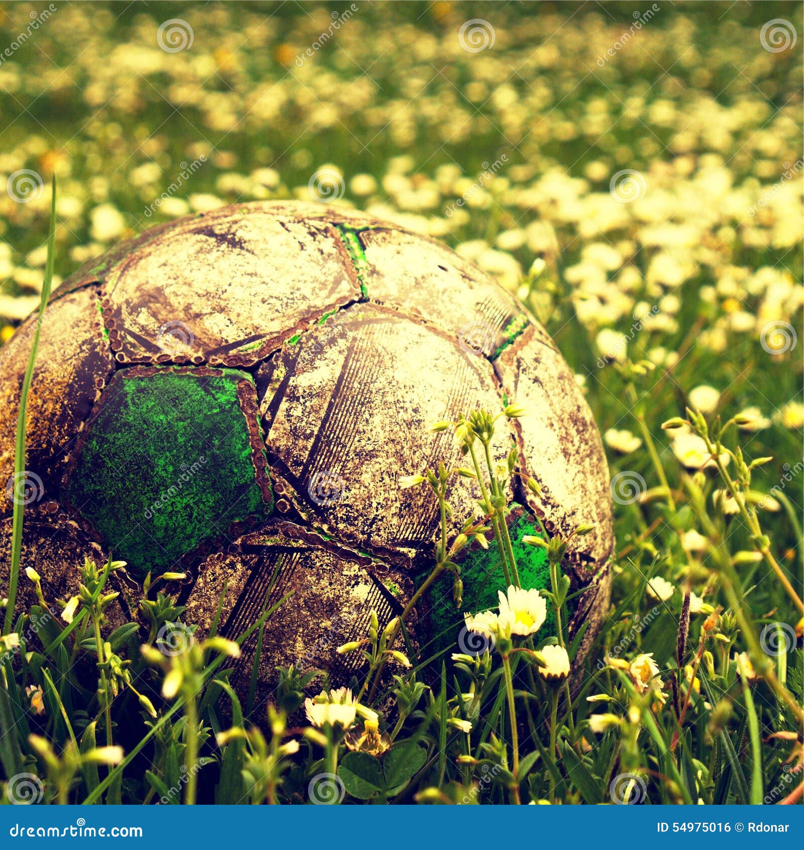 Um garoto segurando a velha bola de futebol antes de começar um jogo de  futebol