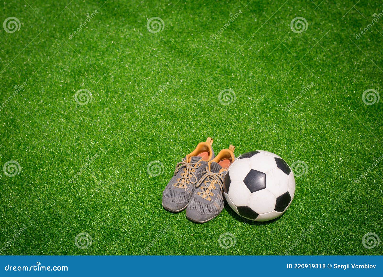 Foto de Bola De Futebol E Sapatos No Campo De Jogos De Futebol e