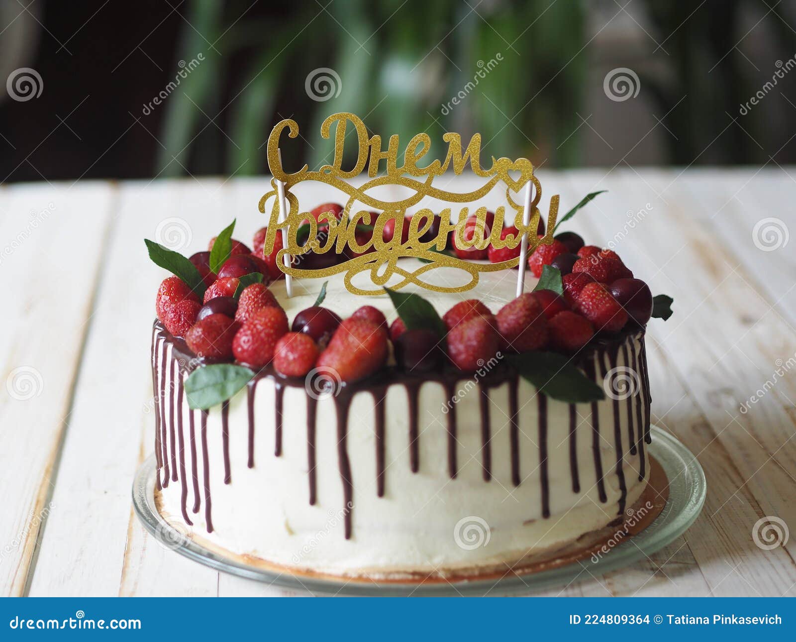 Bolo de aniversário coberto com frutas vermelhas e gotas de chocolate na  toalha de mesa branca conceito moderno de padaria